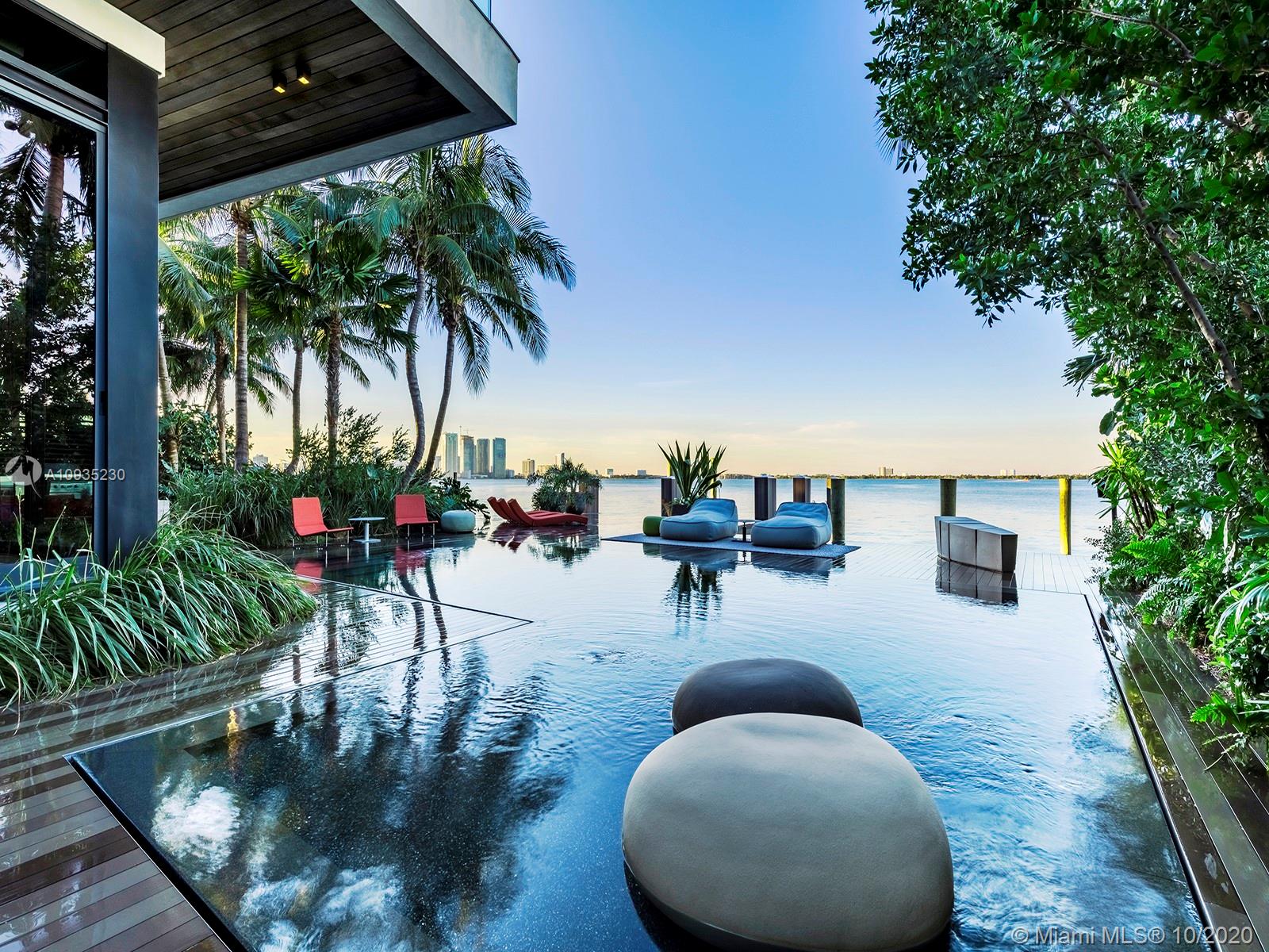 This exquisitely crafted residence on Miami Beach’s Venetian Islands offers a level of design, functionality, and beauty rarely seen in private residential construction today. Secluded, yet enveloped by spectacular sunset vistas of Biscayne Bay, the home is an architectural masterpiece. The floating white oak staircase ending at a 2,300 square foot rooftop lounge, and the fully retractable impact-resistant glass walls create seamless living between indoors and outside. No detail nor luxury is spared, with interior features including a 2,000 bottle wine cellar, a well appointed master suite, the Creston smart home, to the outdoors with negative edge saltwater pool, three outdoor kitchens, and lush native landscaping.