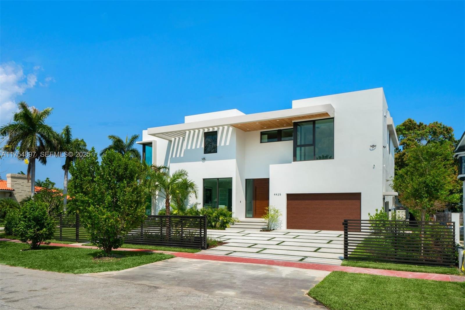 Presenting a brand new just completed 6-bed, 6.5-bath masterpiece on an oversized corner lot in Miami Beach. The residence boasts impressive 21-foot high ceilings in the living room, luxurious Italian porcelain flooring, and a beautiful kitchen equipped with quartz countertops & Subzero/Wolf appliances. The primary suite features 2 private balconies, generous his & her closets, and an expansive bathroom. Five additional bedrooms, each with ensuite bath, provide comfort and privacy for family and guests. Step outside to enjoy the serene saltwater pool, hot tub, and expansive patio area. With a 5-car driveway and 2-car garage, this property offers both ample space and convenience. Located near top-rated schools & pristine beaches, this home offers a lifestyle of luxury and accessibility.