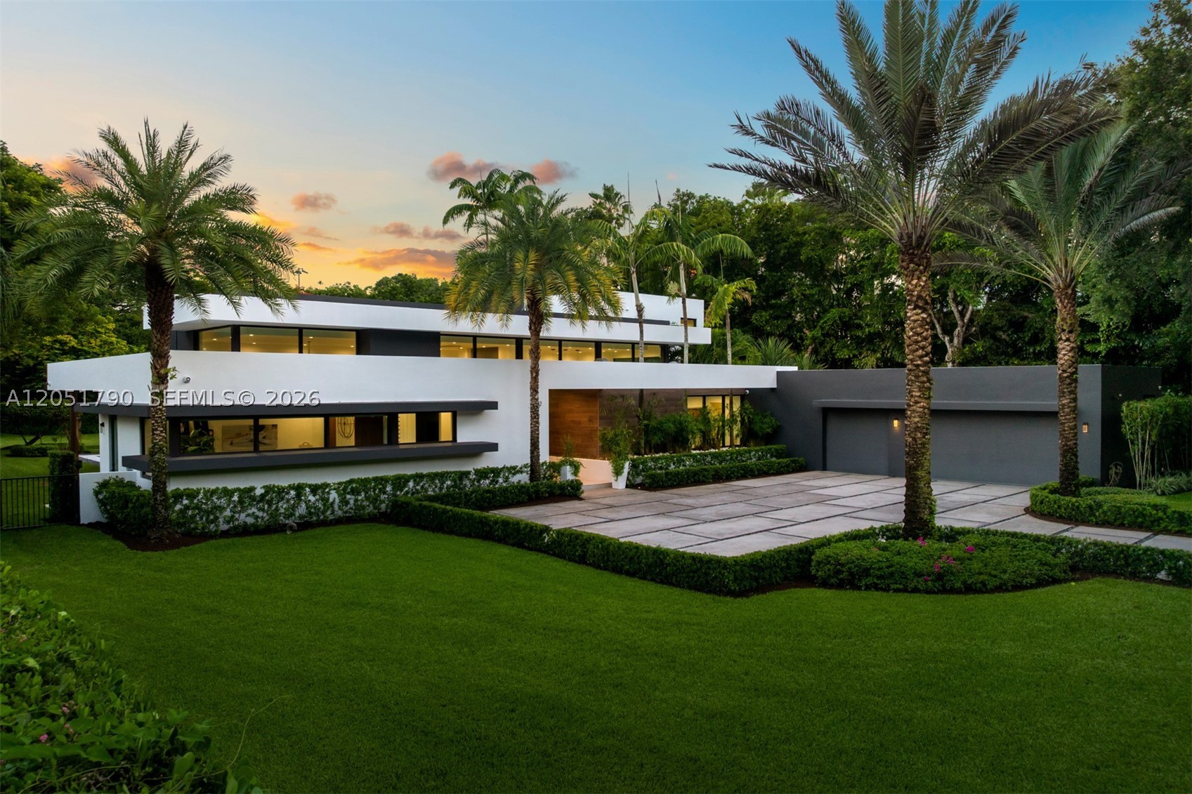 Set behind private gates on nearly an acre in one of Pinecrest's most coveted settings, this exceptional contemporary estate embodies refined architecture and effortless luxury. A thoughtfully designed two-story floor plan offers 6 bedrooms, 7 full baths, and 1 half bath, with the primary suite privately situated on the main level, featuring tranquil views of the resort-style grounds and a spa-inspired bath with a freestanding soaking tub. Walls of impact glass flood the interiors with natural light, while expansive living spaces, complemented by a sophisticated living room wet bar, flow seamlessly to a covered terrace overlooking the heated saline pool with a tanning ledge, summer kitchen, and cabana bath. The gourmet kitchen is appointed with designer appliances, a wine cooler, and a generous walk-in pantry. Upstairs, spacious en suite bedrooms open to a sweeping terrace. Complete with a whole-house generator, a three-car garage, mature tropical landscaping, and a private gated entrance, this remarkable residence offers an exceptional blend of privacy, craftsmanship, and timeless contemporary design.
