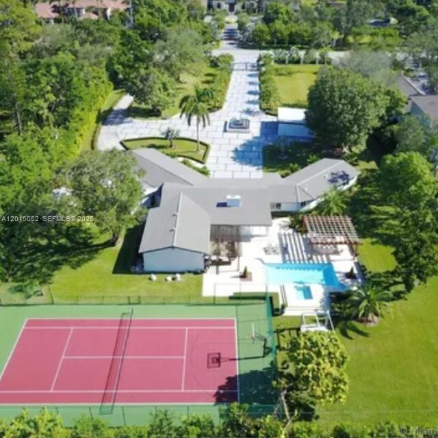 Occasionally, a property is so exquisite, so extraordinary, it stops you in your tracks. Your breath catches, your eyes widen, and for a moment, you are left in awe. This is that property.  Nestled on an exclusive gated 2-acre estate, centrally located, in the heart of South Miami, moments from Coral Gables, this magnificent smart residence offers privacy, elegance, and convenience, all controlled from your phone.  The home features five spacious bedrooms and four beautifully appointed bathrooms, including a cabana bath, plus a separate media room for intimate family evenings or sophisticated entertainment. Renovated in 2017, it showcases soaring vaulted ceilings and timeless sophistication throughout.  Two climate-controlled storage suites with electricity provide versatility and functionality. A two-car garage complements the expansive grounds, which also offer parking for up to 50 vehicles, along with a dedicated service entrance.  Outdoors, the estate transforms into a private resort oasis with a saltwater heated pool and jacuzzi, a fully equipped outdoor kitchen, and a covered terrace designed for elegant gatherings under the Miami sky.  The property also boasts private tennis and pickle-ball courts, lush tropical landscaping, a stunning Tiki Hut, and luxurious details throughout. This is more than a home; it is a sanctuary tucked within one of Miami’s most desirable neighborhoods.  Adding to its exceptional value, the expansive grounds offer subdivision potential, creating a rare opportunity for developers, investors, or families seeking to build an additional residence while preserving the estate’s privacy and grandeur. A rare masterpiece!
