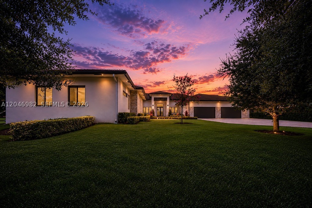 Contemporary elegance meets estate living in this exceptional Plantation Acres retreat, privately set on more than an acre at the end of a quiet cul-de-sac. Thoughtfully designed with 6,360 A/C square feet, the residence offers 5 spacious en-suite bedrooms, 6 full baths, & 4-car garage, blending sophisticated design w/everyday functionality. The expansive open-concept floor plan is defined by soaring ceilings, oversized porcelain tile flooring, linear A/C diffusers, & walls of impact glass that create an effortless connection between indoor/outdoor living. Anchoring the home is a designer kitchen featuring custom 2-tone cabinetry, quartz countertops, an oversized island with prep sink, premium Thermador appliances, a walk-in pantry, wine cooler, and striking gold hardware. Versatile living spaces include a game room, climate-controlled storage, and a private guest retreat complete with its own living room, kitchenette, and full bath, ideal for long-term guests, or multi-generational living. The resort-inspired backyard invites year-round enjoyment w/heated saltwater pool, expansive paver patio, and sprawling acre-plus grounds offering endless possibilities. Additional highlights include impact windows and doors, city water, a paver driveway, a 25-camera security system, and newer 2022 construction. All within one of Plantation Acres' most coveted neighborhoods, just minutes from American Heritage School, upscale shopping, fine dining, and South Florida's premier destinations.