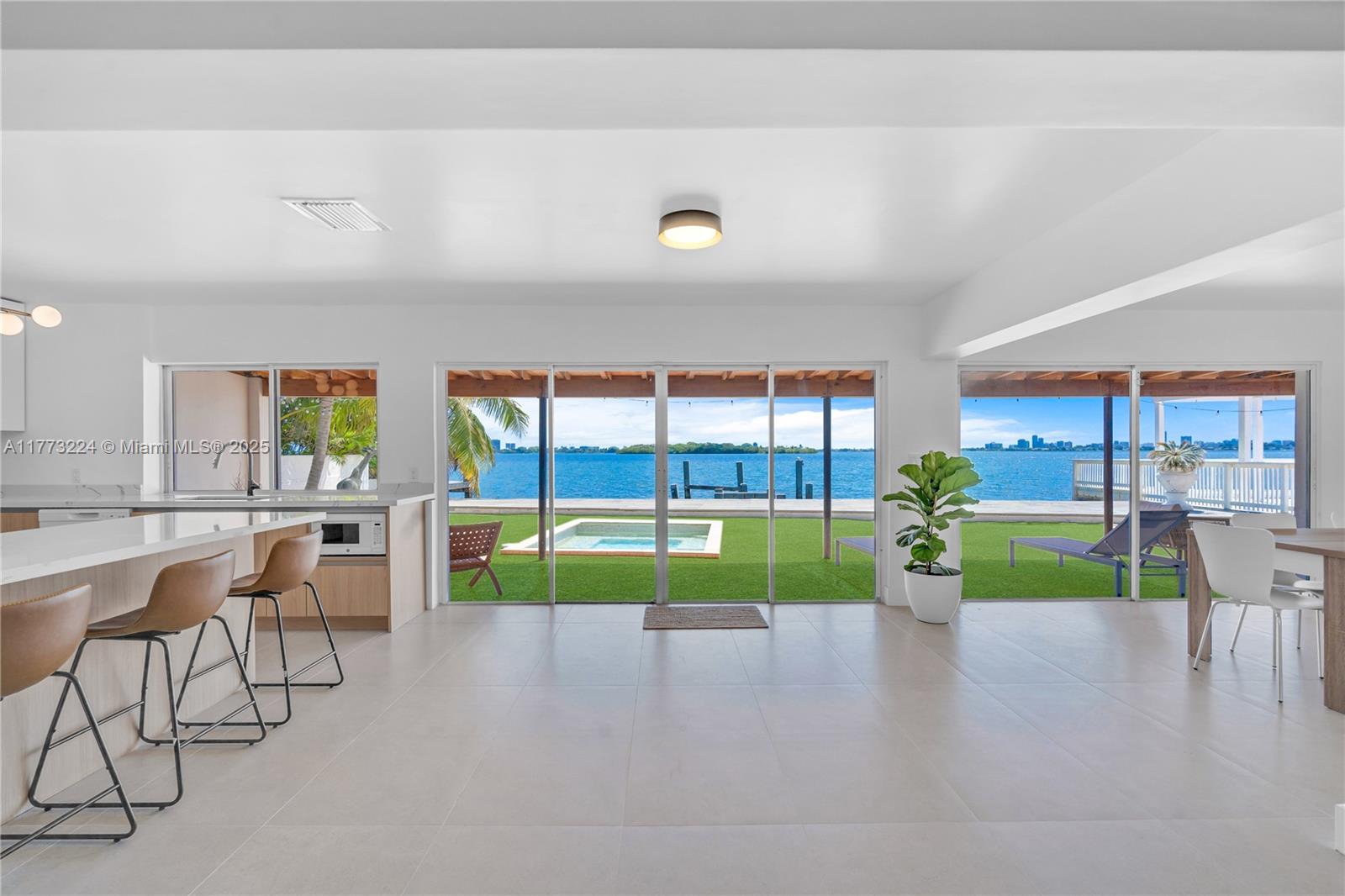 Prepare to be captivated by breathtaking, unobstructed views of Biscayne Bay from this beautifully updated residence in the heart of Biscayne Shores. From the moment you step inside, the expansive open living spaces draw your eyes straight to the mesmerizing panoramic bay views. Centrally located just 15 min. from Surfside & Bal Harbour beaches this home blends serene waterfront living with unbeatable location. Also just minutes from the Design District, MIA, Miami Shores Golf & Country Club, as well as a variety of grocery stores and dining options. The 3BR/3BA main home is thoughtfully designed with an airy, open-concept. An attached 1BR/1BA guest suite with a private entrance provides the ideal setup for guests or live-in accommodations. 68 feet of waterfront ready to build a dock.