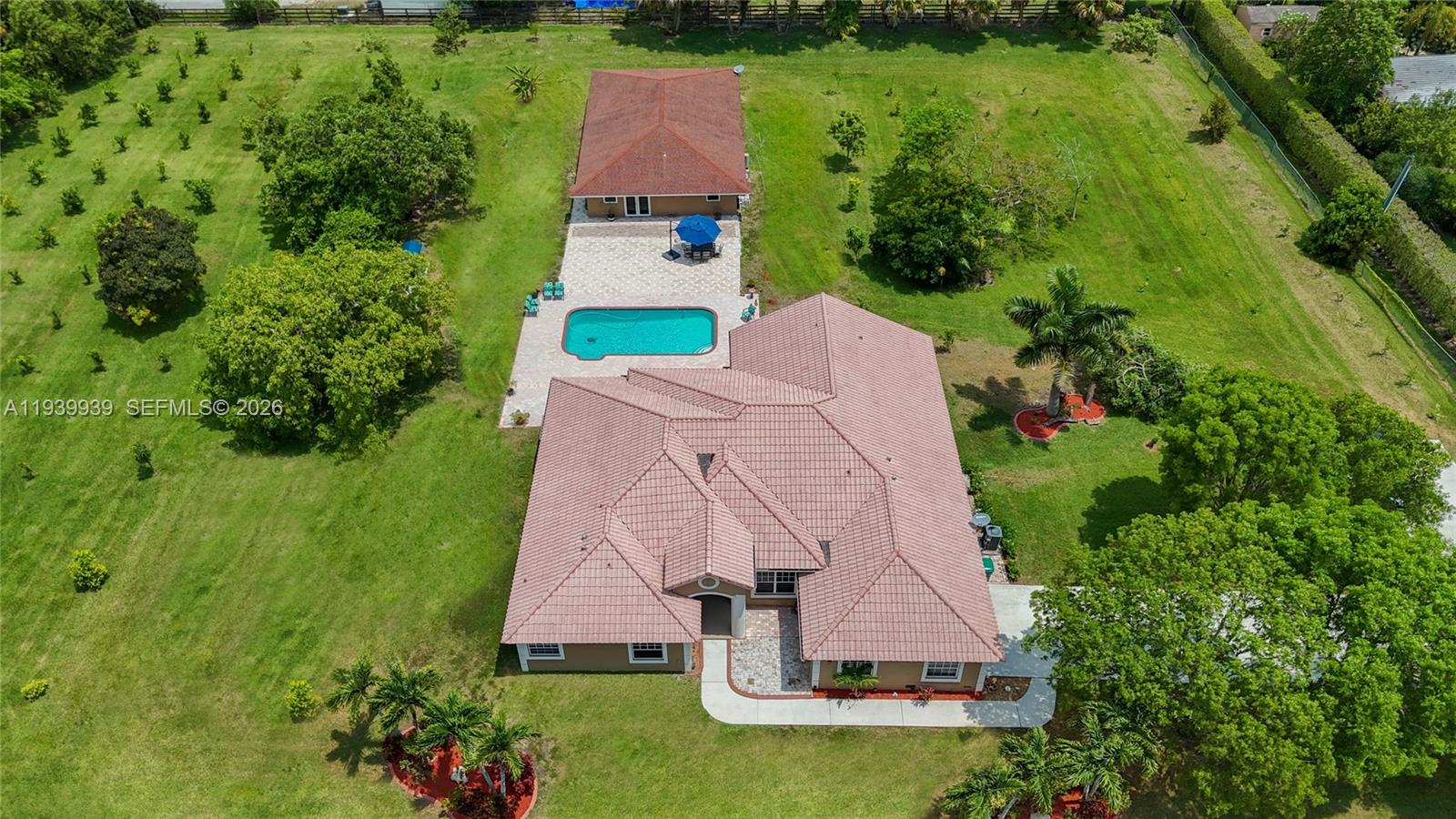 New Year, New Opportunity! Priced to sell. Well below appraised value. Fully fenced and gated 2.2-acre estate in equestrian-friendly Southwest Ranches. 5-bedroom residence plus a separate 2-bedroom guest house-ideal for multi-gen living, a home office, rental income, etc. The main home offers 3,000+ living sq ft, volume ceilings, abundant natural light, 2-car garage, and expansive driveway. The detached, updated guest house boasts 1,300+ sq ft, a storage room, private laundry, and a 3-seat Jacuzzi. Property features new A/C systems, new water heaters, new well pumps and water filtration systems. Newly installed municipal water line directly across the property, makes city water connection easy and optional if desired. No overhead power lines running through the property. Current agricultural exemption with citrus, tropical, and exotic fruit trees.