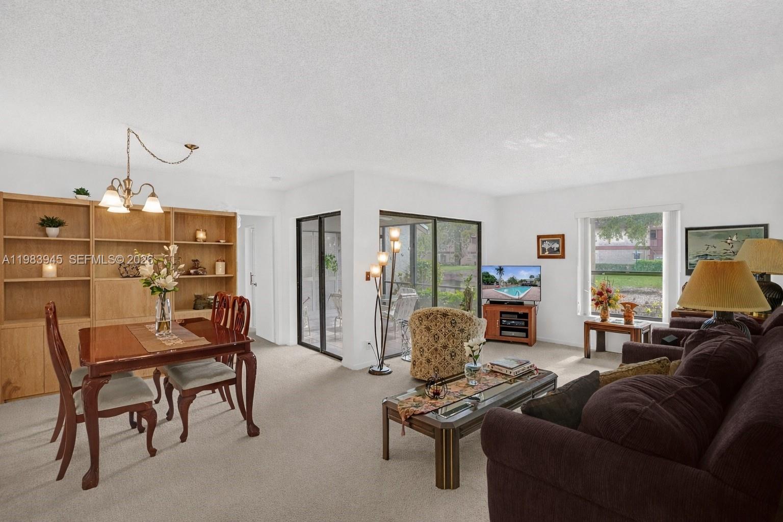 Spacious first floor corner residence overlooking a peaceful pond. This bright home is filled with natural light from all windows and features an open living and dining area that flows seamlessly to a screened patio, perfect for enjoying the water views. The primary bedroom offers a large walk in closet, and the residence includes a convenient in unit washer and dryer. The condo has been impeccably maintained mostly in its original condition, giving a new owner the opportunity to design the space to their personal style. This condo community is part of the The Township at Coconut Creek, offering many amenities, including a clubhouse, performing arts theater, fitness center, aquatic center, olympic style pool, sports park, tennis courts, racquetball courts, billiards, and scenic walking paths. Conveniently located near shopping, dining, parks, and major roadways.