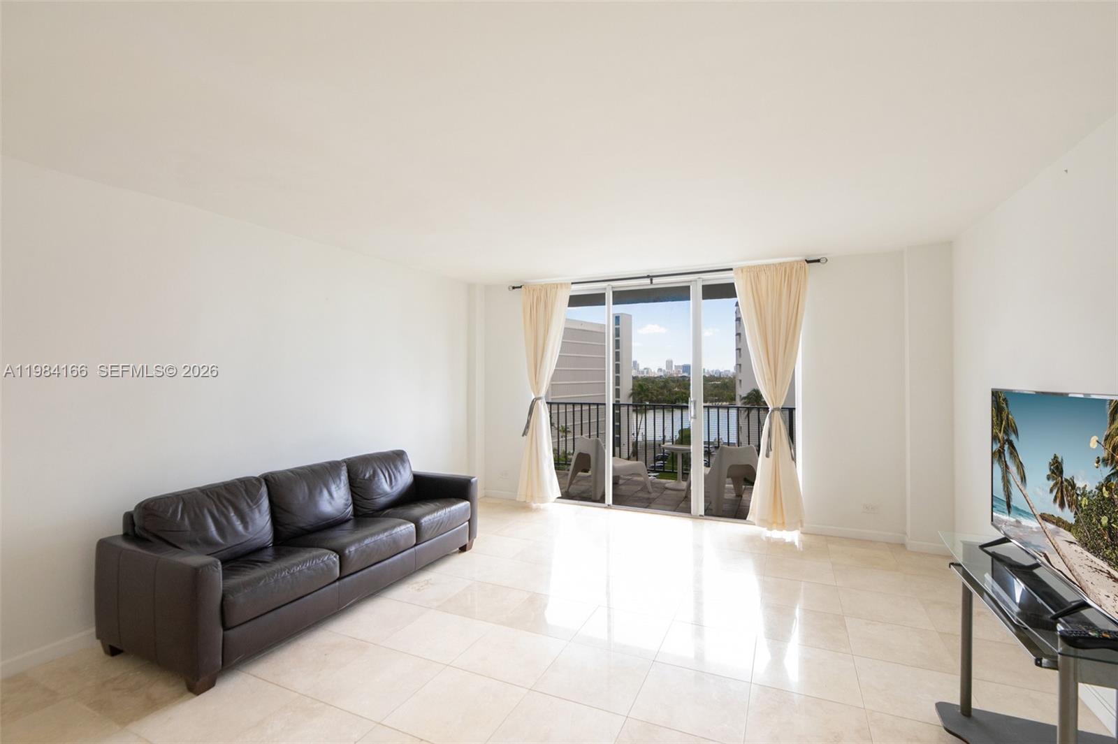 This spacious 1-bedroom, 1.5-bath condo offers abundant natural light as a top-floor corner unit with desirable South and East exposures and beautiful bay views. Enjoy a large private balcony with expansive water views, perfect for relaxing or entertaining. The unit features marble floors throughout the living room, kitchen, and bathrooms, with warm laminate wood flooring in the bedroom. The updated kitchen includes granite countertops, modern cabinetry, and stainless steel appliances. The unit offers ample closet space throughout. Additional highlights include a large assigned storage unit and designated parking. The building has completed its 50-year recertification, with a new roof installed last year, along with a renovated lobby, gym, and spacious pool area with BBQ facilities. Ample guest parking is also available. Ideally located within walking distance to parks, the beach, houses of worship, and A-rated Ruth K. Broad Elementary and Middle School. Enjoy proximity to excellent restaurants, shopping, and local amenities. Cable and internet are included in the maintenance. Easy to show!