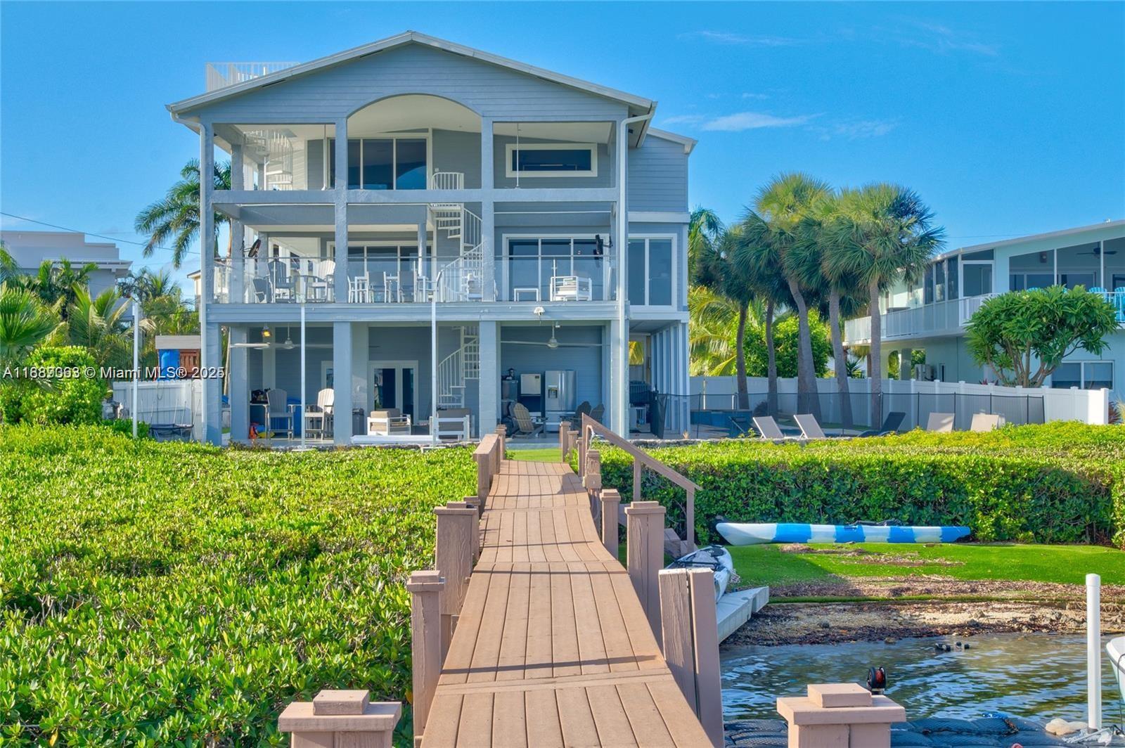 Paradise awaits in this elegant bayfront home in Buccaneer Point. With 4 beds, 4 baths, and wraparound verandas
 offering panoramic bay views, this residence blends coastal charm with modern comfort. Enjoy a private dock with
 boat lift, sandy beach access, and a chef's kitchen with granite counters and stainless appliances. The third-floor
 primary suite features a private balcony and spa-style tub, all accessible by elevator. Complete with a spacious
 garage and storage for all your water toys- this is true Keys living at its finest