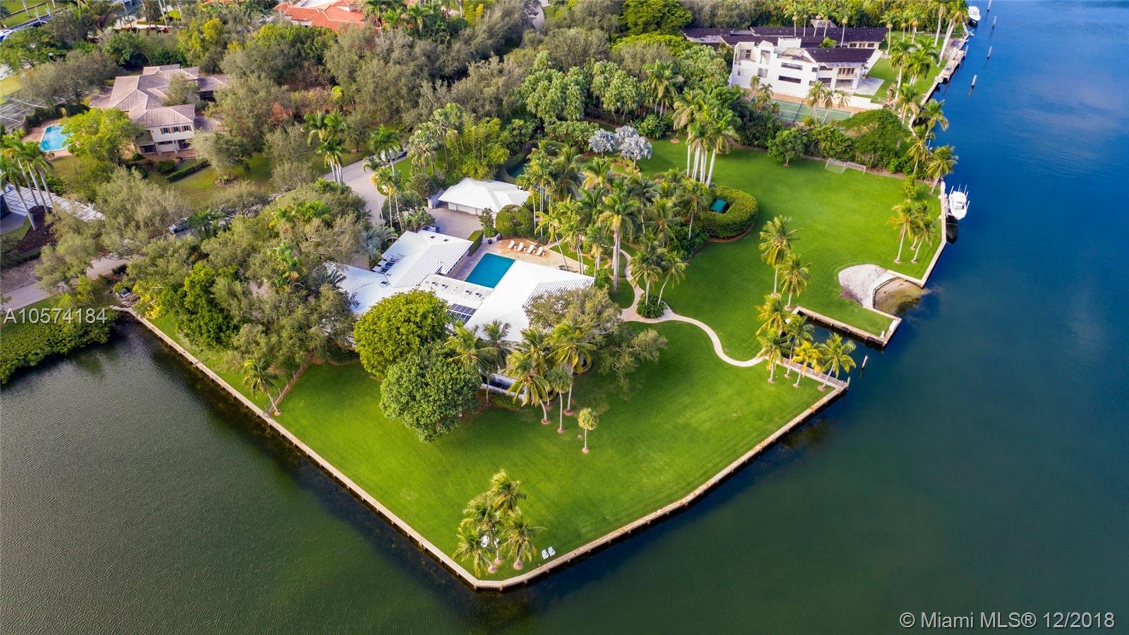 A once in a lifetime opportunity to purchase one of the largest parcels of land situated within the secure gates of Gables Estates.  The property is over 3 acres with 750 feet of water frontage on a wide water basin with endless unobstructed views leading to the bay. This magnificent residence offers limitless areas for entertaining with infinite water views, lush gardens, a pool, grandfathered in tennis court and private beach. Room for up to 150’ yacht.