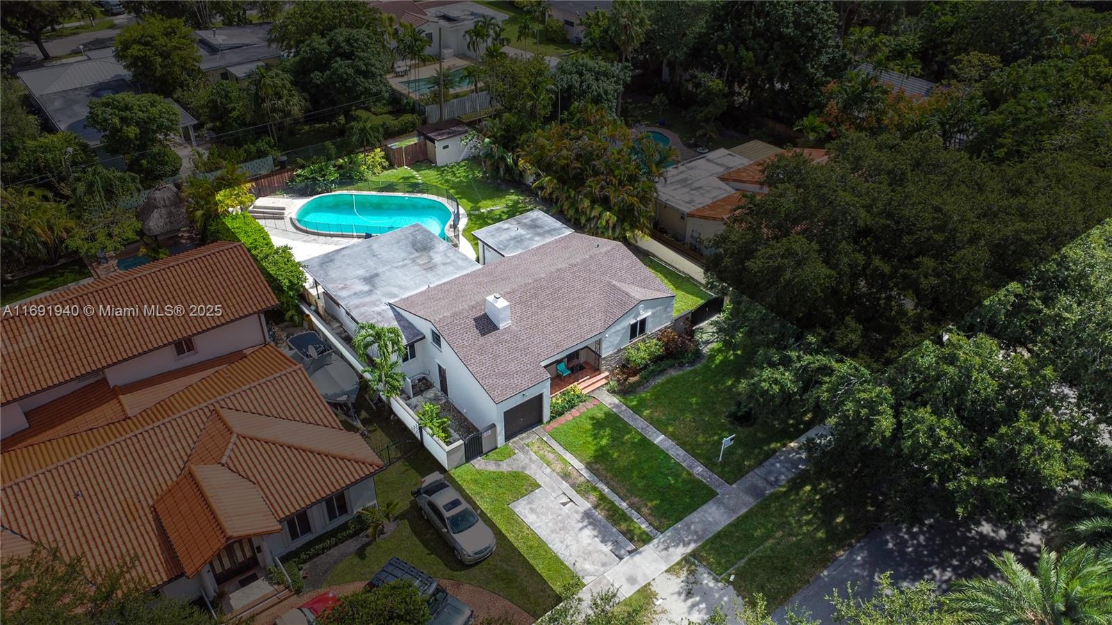 Located in the heart of Miami Springs, this charming home offers the delights of nature and tranquility. Beautiful old trees surround the neighborhood, and the property is within walking distance of one of Miami’s most famous golf courses. Miami International Airport is 5 miles away for those who love to travel. It is built on a 10,650 sq ft lot. The home features an enclosed patio with a 5-foot concrete wall, a garage, plenty of space for a boat, and a unique 20'x40' midcentury style pool with a terrace with a grilling area. In addition, it offers a NEW ROOF, NEW IMPACT WINDOWS,,,,. This property is perfect for golf lovers with a harmonious life, green streets, warm wood floors, and the charm of the years!