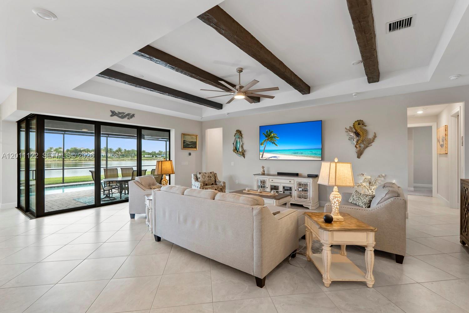 This one-of-a-kind LUXURY RESIDENCE offers serene WATER VIEWS ON THREE SIDES, breathtaking sunrise and sunset vistas, and a SALTWATER POOL & SPA, all within the 55+ Del Webb Naples community. Better than new construction, this STELLAR floor plan, built in 2023, offers 3 bedrooms, 3 full baths, and a den with designer finishes throughout.

The DESIGNER KITCHEN features soft-close cabinetry with pull-out drawers, UPGRADED APPLIANCES, a large entertaining island, SILGRANIT sink, BEVERAGE CENTER, CUSTOM PANTRY, and ZERO CORNER SLIDERS for seamless indoor-outdoor living. Additional upgrades include designer lighting, upgraded interior paint, Sonos sound system, custom WINDOW TREATMENTS, and upgraded bedroom carpeting.

The luxurious PRIMARY SUITE showcases a spa-like bath with a floor-to-ceiling tiled shower, upgraded shower head, dual sinks, upgraded lighting, and CUSTOM CLOSET system. Outside, enjoy the screened-in HEATED SALTWATER POOL & SPA with remote access overlooking a WIDE LAKE VIEW, enhanced by Florida glass and lush landscaping for privacy. The LANAI includes Sonos surround sound, TV, fire pit, and furniture, all INCLUDED, creating the perfect entertaining space.

Storm Smart ELECTRIC HURRICANE SCREENS and IMPACT WINDOWS provide peace of mind. The Seller is also offering a one-year Platinum HOME WARRANTY. Completing the home is an OVERSIZED 3 CAR GARAGE with a 4' extension, epoxy floors, shelving, EV charger, and smart openers.