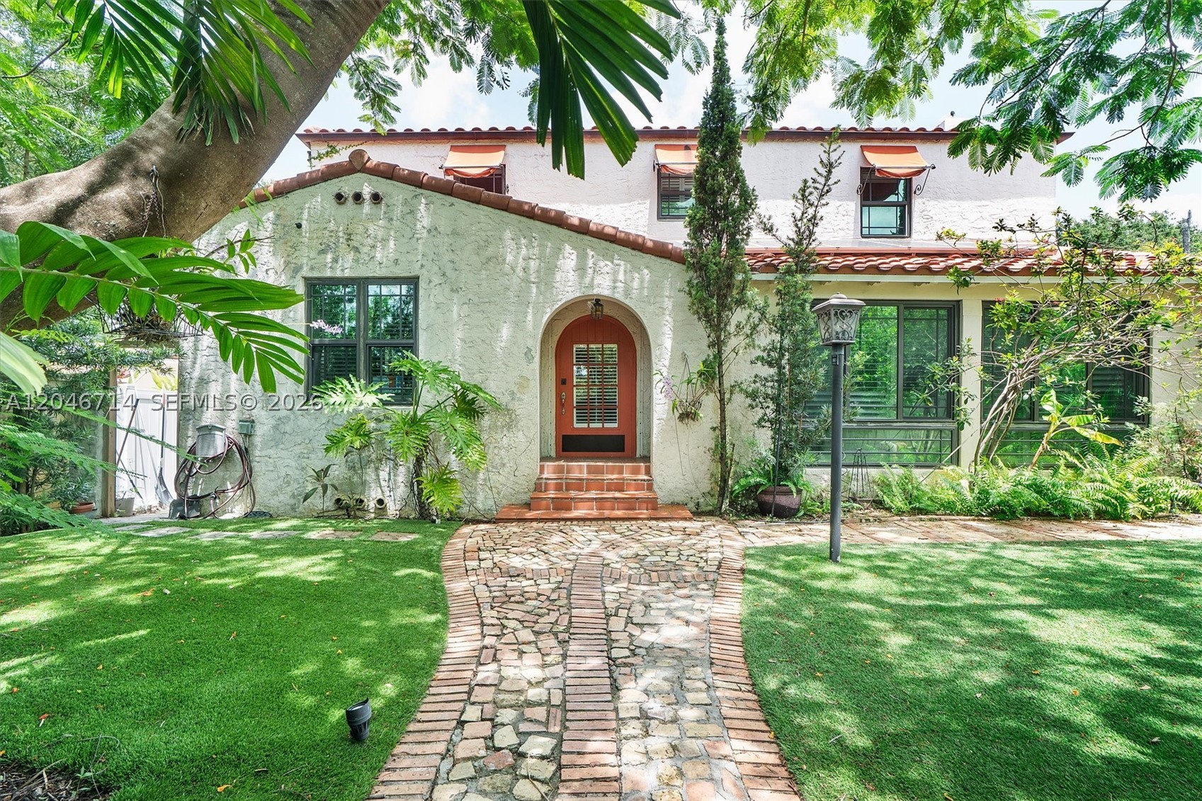 Blending timeless Spanish-inspired architecture with thoughtfully curated modern updates, this exceptional two-story residence offers comfort, style, and functionality on an expansive 15,000± sq. ft. lot. 2018 ROOF AND 2917 AC! IMPACT WINDOWS AND DOORS! A private walled entry and detached 2-car garage create a secluded retreat, while the home's classic character shines through with hardwood floors, exposed wood beams, and a fireplace. The renovated kitchen serves as the heart of the home, complemented by recessed lighting. Energy efficiency and peace of mind come standard with owned solar panels and two Tesla Powerwall batteries, providing backup power during outages. Step outside to a spacious backyard designed for effortless entertaining. Enjoy a fully equipped outdoor kitchen featuring a built-in grill, sink, and refrigerator. Cabana Bathroom! The custom pool and spa become the centerpiece after sunset with elegant lighting that transforms the space into a true backyard oasis.