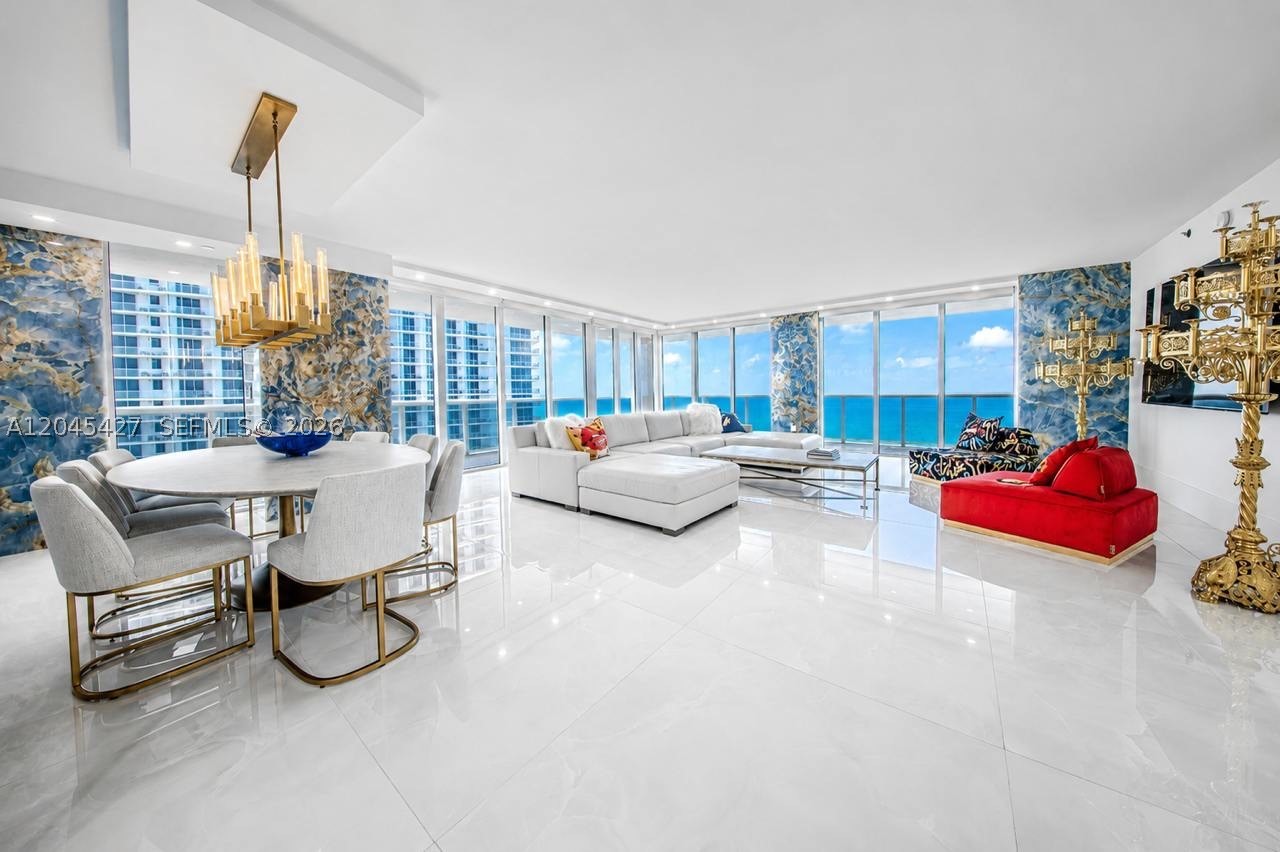 This exceptional, fully renovated residence is a true masterpiece of contemporary coastal design, offering 2,078 square feet of refined oceanfront living in the highly sought-after Beach Club III. Situated on a high floor, the residence showcases breathtaking, unobstructed views of the Atlantic Ocean and the city skyline from nearly every room. An expansive wraparound terrace creates the perfect setting to enjoy spectacular sunrises over the ocean and unforgettable sunsets across the skyline. Designed with both elegance and functionality in mind, the open-concept living and dining areas flow seamlessly into a stunning chef’s kitchen featuring striking white countertops, custom cabinetry, premium appliances. A dramatic backlit natural onyx backsplash and walls serve as the home’s signature design element, creating a truly unforgettable focal point. Custom designer lighting, high-end finishes, and impeccable craftsmanship elevate every space throughout the residence. A beautifully designed custom walk-in closet with concealed floor-to-ceiling cabinetry, providing abundant storage while maintaining clean architectural lines.  Beach Club III is one of Hallandale Beach’s premier oceanfront communities, offering an unmatched resort lifestyle with three oversized pools, a spectacular two-story spa and fitness center, a full-service restaurant, beach and pool service, 24-hour security, valet parking. A rare opportunity to own a truly one-of-a-kind, move-in-ready residence.