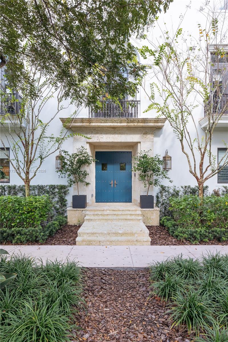 Located in Coral Gables on a picturesque tree-lined street, this refined corner residence reflects Spanish-Colonial brownstone architecture. Filled with natural light, the home offers expansive loggias that create seamless indoor-outdoor living. The three-story layout features approximately 4,250 square feet of interior space, highlighted by a dramatic skylit staircase, twelve-foot ceilings, bespoke millwork, curated designer wall coverings, and Portola specialty finishes. Additional features include a marble-clad chef’s kitchen with Wolf and Sub-Zero appliances, butler's pantry, Waterworks fixtures in all bathrooms, custom closets, a fully integrated Crestron smart-home system, climate-controlled wine room with custom racking, a private elevator, fully appointed summer kitchen within the loggia, two laundry rooms, and a rare four-car garage. Ideally located, offering the rare balance of walkable village charm, and the refined, enduring lifestyle that defines Coral Gables