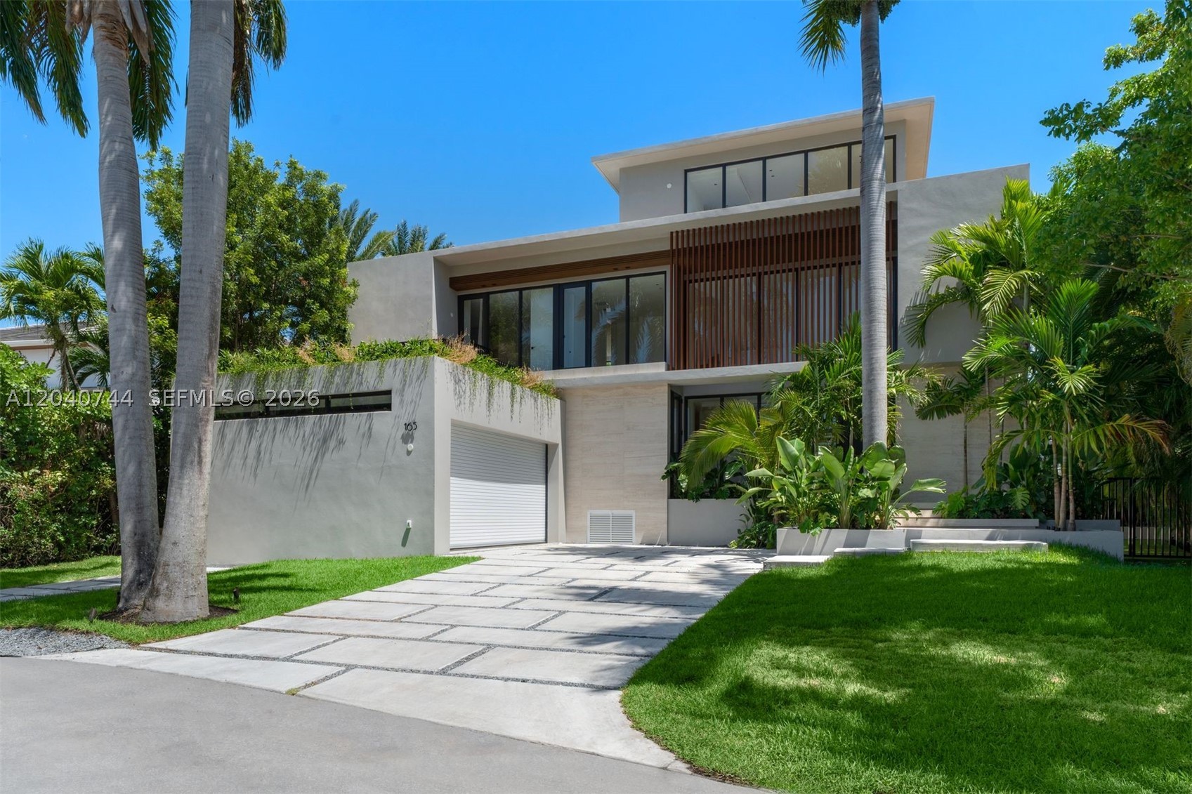 There are homes that are beautiful, and then there are homes that leave a lasting impression. This extraordinary brand-new 2026 designed by Kubik is one of a kind.  With breathtaking architecture, exceptional attention to detail, and a floor plan designed for the way people truly live today, this is a home that immediately captivates from the moment you enter. Filled with natural light and generous open spaces, every room feels inviting, comfortable, and connected to the beauty that surrounds it. The residence offers 6 bedrooms, 8 full bathrooms, and 1 powder room, along with a spectacular rooftop terrace and an additional flexible space that could become a private gym, office, yoga studio, art room, or peaceful retreat. A dramatic spiral staircase serves as a beautiful architectural centerpiece, adding character and elegance to the home's design. The primary suite is particularly special...surrounded by lush gardens, it feels worlds away from everyday life. The spa-like bathroom further enhances the feeling of escaping to your own boutique resort. Created with family gatherings and entertaining in mind, the outdoor spaces are every bit as impressive as the interiors. The pool, spacious terraces, and barbecue area provide the perfect backdrop. Offered completely turnkey and finished with impeccable taste including a 2 car-garage and elevator, rarely does a newly constructed residence combine such striking architecture with so much warmth and soul, creating a masterpiece.