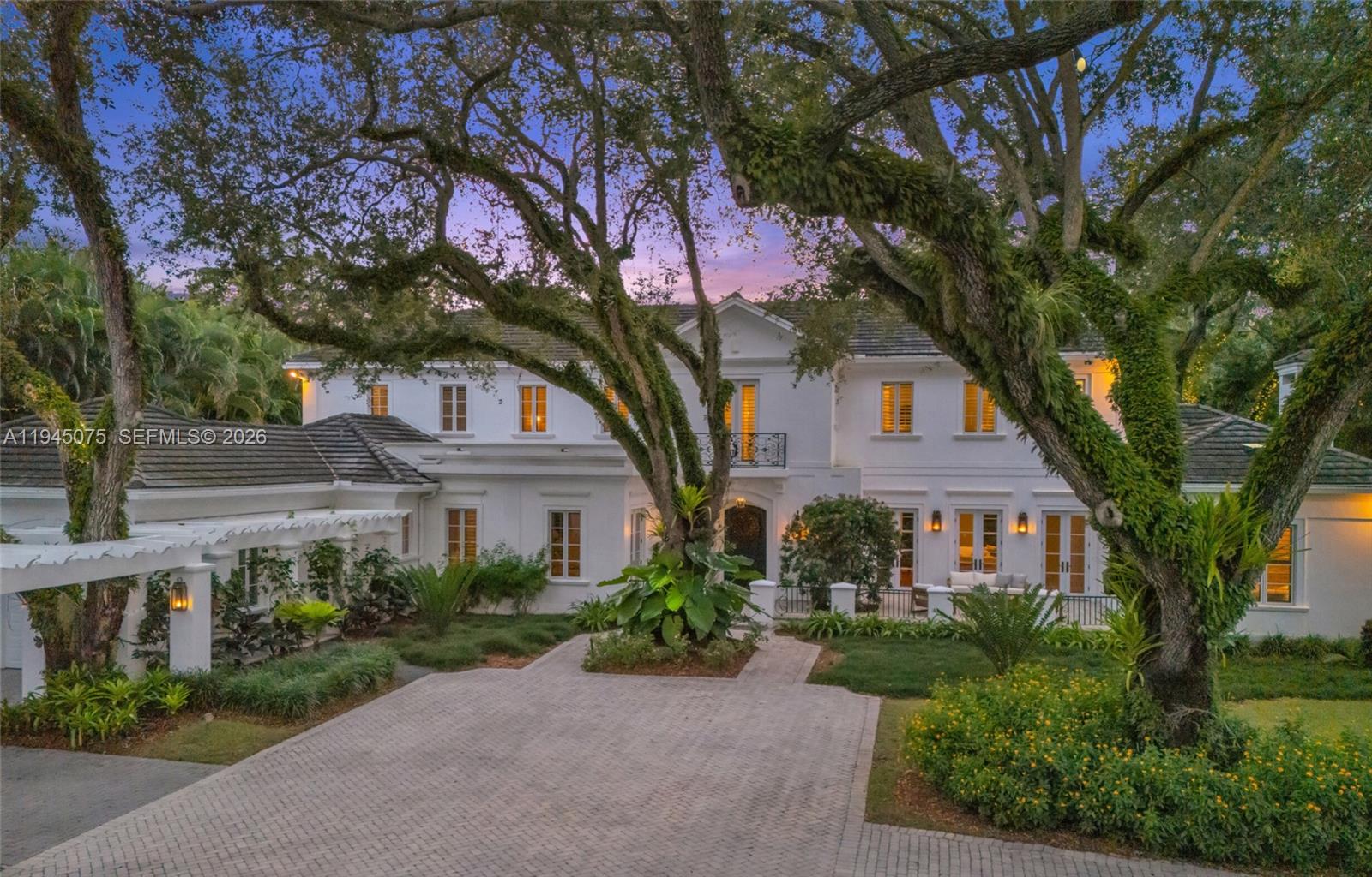 Anything but average. Set inside Stonegate, a private enclave of just 12 homes in Miami's Ponce Davis neighborhood, this French Provincial estate occupies a rare end position on a 32,496 sq ft oak-canopied lot. The approach is long and intentional. Inside, 6,135 sq ft feels warm, grounded and thoughtfully scaled, featuring 6 en-suite bedrooms, including a private upstairs primary suite, a grand library/den, and spaces designed to be lived in. The kitchen & living areas open naturally to a covered patio, pool, fire pit, and sunken trampoline, creating a setting equally suited for everyday life and entertaining. With a 3-car garage, full home generator, smart systems, & guarded entry from dusk to dawn, this home speaks to buyers who value discretion, permanence, and quality over spectacle.