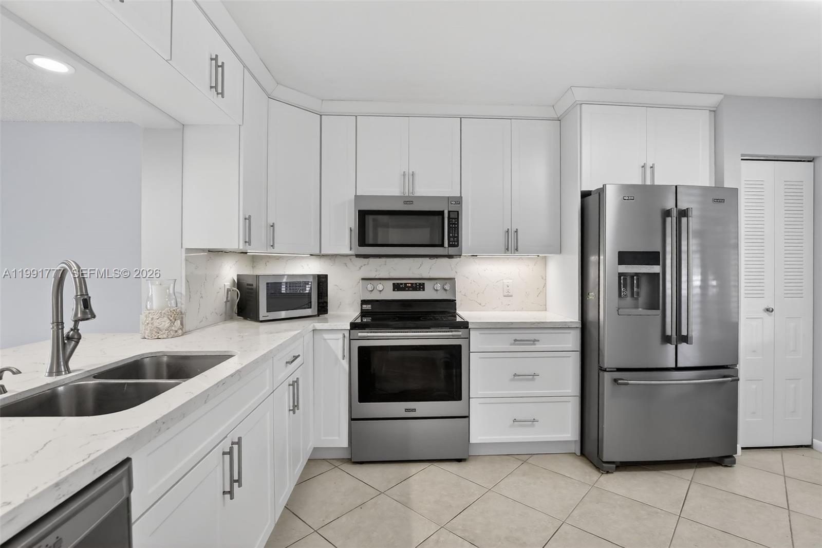 Wow—do not miss this opportunity to live in a beautifully updated 2-bedroom, 2-bathroom ground-floor condo, meticulously remodeled with contemporary design upgrades throughout. This stunning unit features white shaker cabinets, elegant granite countertops with a matching backsplash, stainless steel Maytag appliances, and tile flooring throughout the entire home. The widened pass-through creates an open and inviting layout, allowing you to enjoy seamless views from the dining area straight out to the patio. Step outside and take in a breathtaking panoramic eastern exposure overlooking the manicured golf course, lush landscaping, and one of the community’s tranquil ponds.
Designed for both comfort and privacy, this unit offers a peaceful, secluded feel while still being ideally located. It is nestled near the clubhouse, within walking distance to both the main clubhouse and a conveniently located satellite pool. The building itself is considered one of the best in the entire community, offering easy access to both entrances. A stackable washer and dryer are also included for added convenience.