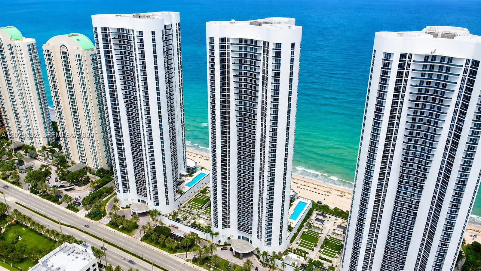 This luxurious two-bedroom, two-bathroom oceanfront lanai condo offers 1,850 square feet of living space, complete with an oversized private terrace that opens directly to the pool deck. With the charm of a beach house, it features a soaring living room ceiling and stunning views through 10-foot floor-to-ceiling windows. The spacious master suite includes its own bathroom, while the modern kitchen is perfect for entertaining. Exclusive beachfront perks include private beach chairs, an oceanfront gourmet restaurant with delivery right to your spot, a lavish clubhouse, a state-of-the-art gym, his and her spas, two lap pools with attendants, valet service for two cars via an on-call app, and a business center. The property also boasts a spectacularly renovated patio and pool area.