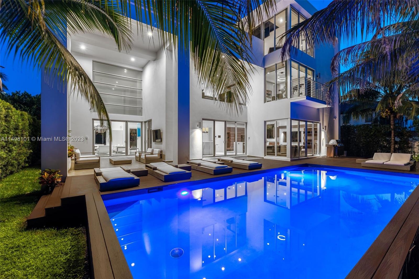 Welcome to this sleek three-story smart home, just a block from the ocean. The kitchen boasts top-notch Sub-Zero, Wolf, and Miele appliances, along with stone countertops and custom Mia Cucina cabinetry. A glass elevator seamlessly connects the spacious rooms.
The third-floor primary suite spans nearly 2,000 square feet, offering custom double walk-in closets, a separate office area, and floor-to-ceiling windows overlooking tropical landscaping. A rooftop deck with a TV and audio system adds an extra layer of luxury. The primary bath features marble floors, a slate shower, and double vanities.
The private pool area sits on a custom wood deck with a high-end A/V system, creating a lush retreat. Experience the epitome of modern living in this sophisticated coastal residence.