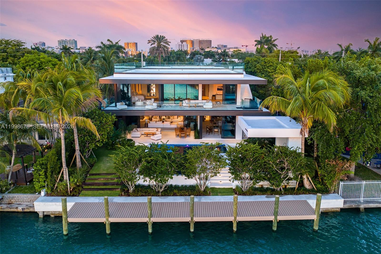 Brand-new waterfront masterpiece in Bay Harbor Islands, offering 8,007 SF under A/C plus a 537 SF air-conditioned two-car garage on a 13,125 SF lot with 80 feet of water frontage. Set in a no-wake zone with dockage for a large vessel and just minutes from Haulover Inlet, it is a true boater’s paradise.

Designed by SDH Studio, with interiors by Alizée Brion and landscape design by CLAD, the home blends refined natural materials with sophisticated modern living. Elevated above FEMA requirements, it features soaring ceilings, dramatic entertaining spaces, custom walnut millwork, shell stone and white oak flooring, limestone accents, Lutron lighting and shade control, Sonos-integrated audio, and seamless indoor-outdoor living.

The home includes a stunning main kitchen, fully equipped chef’s kitchen, heated saltwater pool and spa, waterfall feature, outdoor kitchen, lush tropical landscaping, and a spectacular 2,250 SF rooftop terrace with pickleball rendering.

The private upper level is devoted to a serene primary suite with sitting area, spa-like travertine bath, expansive closets, coffee station, and a dedicated wellness suite with sauna and cold plunge.

A rare offering defined by warmth, scale, craftsmanship, and understated luxury.