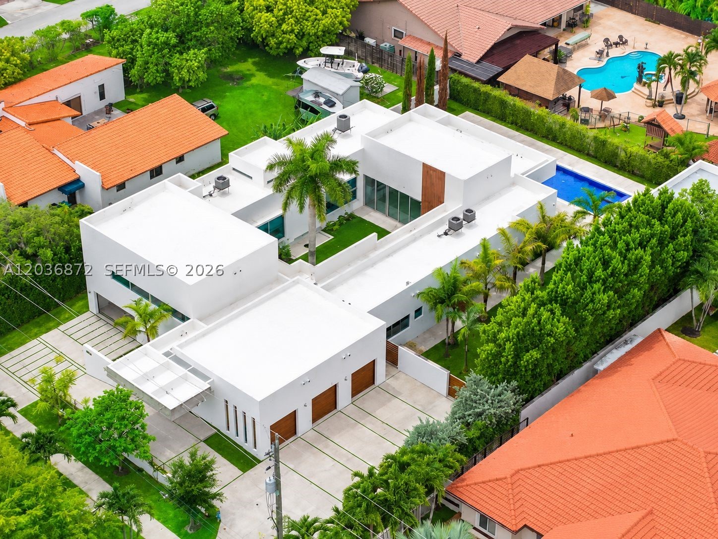 Privately commissioned and custom-built in 2018, this steel-and-concrete Architectural Estate is a rare expression of modern design, privacy, and purposeful living. Encompassing 4,146 SF of living space and 8,253 total SF on an expansive, nearly half-acre homesite (20,909 SF), the residence is organized around a dramatic open-air central pavilion that fills the home with natural light while seamlessly connecting its distinct living environments. Thoughtfully designed to balance connection and privacy, the floorplan features a private primary wing, separate guest and multi-generational accommodations, soaring ceilings approaching 20 feet, exposed architectural concrete, walls of impact glass, and refined contemporary finishes throughout. Expansive retractable glass walls dissolve the boundary between indoors and out, opening to a heated 60-foot swimming pool, covered terraces, a detached culinary pavilion with summer kitchen and event storage, and western exposures capturing beautiful South Florida sunsets. Equipped with Control4 whole-home automation, a secured two-level six-car garage including a lower-level vehicle gallery and storage space, circular motor court, covered carport, and parking accommodations for approximately 15 vehicles. A truly one-of-a-kind contemporary estate designed with purpose, built without compromise, and created to be experienced. Exceptional location in Miami's Western Coral Way corridor. There is no other in comparison.