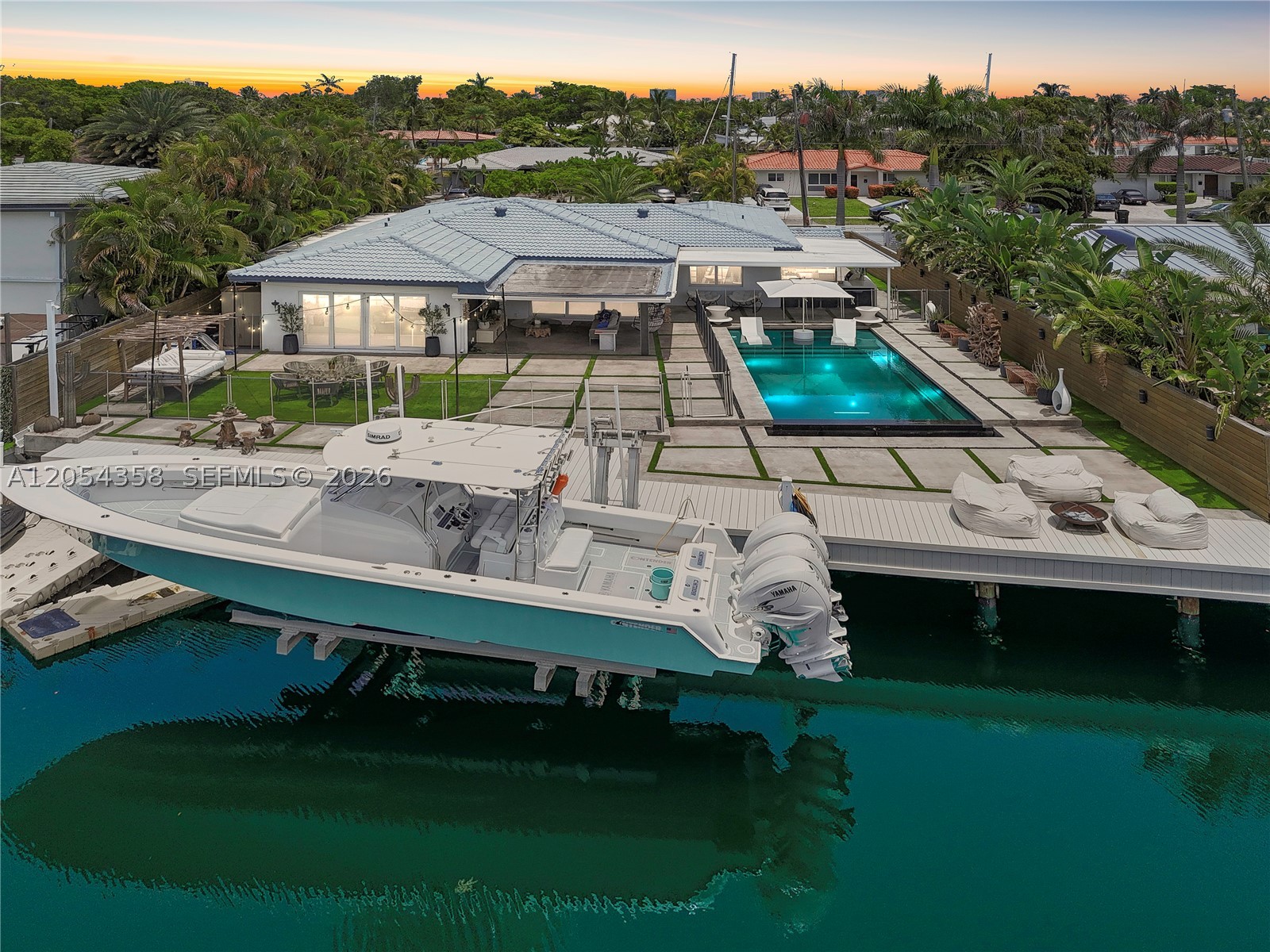 Experience beautifully remodeled waterfront living in prestigious gated Keystone Point! This 3 bedroom,3 bath home offers 75 ft of waterfront with no fixed bridges and direct bay access, a true boater’s paradise. Thoughtfully updated throughout, the home features a new kitchen, updated bathrooms, impact windows and doors, and a brand new concrete driveway with dual approaches. The open concept living room is flooded with natural light through floor-to-ceiling windows overlooking the pool and water. The spacious primary suite also overlooks the water with floor-to-ceiling windows framing beautiful sunset views, plus a large walk-in closet and a luxurious bath with dual vanities, a soaking tub, and separate shower. Outside, enjoy a covered patio, outdoor kitchen, and an expansive backyard with room for a play area or future enhancements. One full bath serves as a convenient cabana bath. Recently updated dock and 35,000 pound boat lift completes the waterfront dream. The garage is currently configured as an Air-conditioned gym with excellent functional space. Gated entry for added security!  Ideally located just minutes from Bal Harbour, the beach, Top-Rated Schools, Whole Foods, shopping, dining, and with easy I-95 access, this move-in ready waterfront home offers the very best of the South Florida lifestyle.