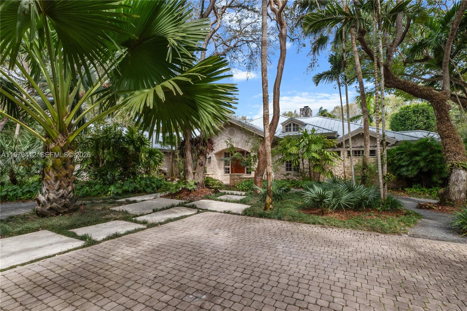 An extraordinary storybook estate offering! Elegant and exquisite home in 24 hour guard-gated Snapper Creek Lakes nestled within a magical canopy setting of ancient oaks on 1.25 lush acres. Reflected by the expansive coral rock exterior, the serenity of the secret grotto, winding walkway leading to the surprising pond. This masterfully crafted residence is truly unparalleled in its architectural design, refined finishes and details. fabulous split floor plan. Formal living and dining rooms, executive office/library. Epicurean gourmet kitchen open to a charming morning room for your breakfast and afternoon tea! Beautiful children's quarter. Separate custom guest house. Additional cabana pool bath. Garden pavilion situated by the inviting large lap pool! Immense in the splendor in every corner of the heavenly garden and nature wander! Over 7,700 SF of luxurious living! Truly a home extraordinaire! See Broker Remarks for showing instruction