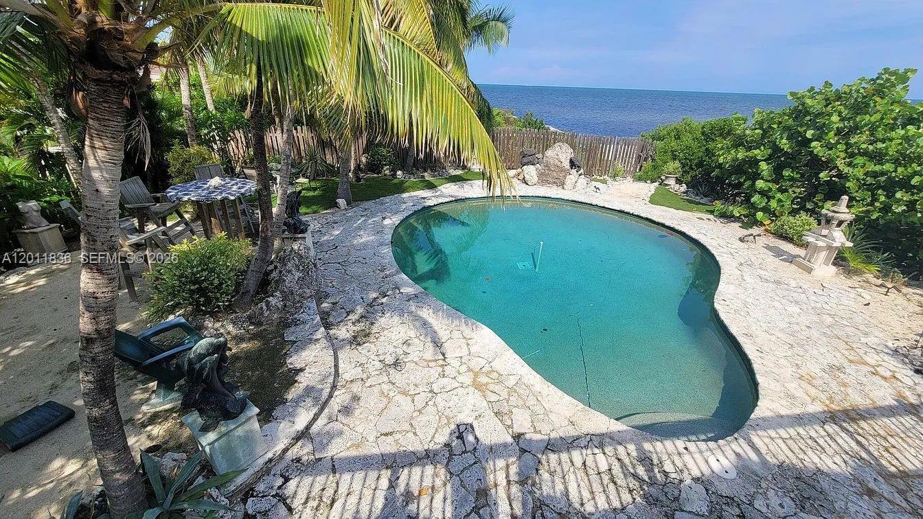Beautifully located in the heart of Key Largo, this charming coastal home offers tranquil ocean views and a private tropical setting. Enjoy your own backyard oasis featuring a refreshing pool, perfect for relaxing or entertaining. The property backs up to a closed canal, providing added privacy and a peaceful natural backdrop. Surrounded by lush landscaping and just moments from the ocean, this home captures the essence of Florida Keys living. A unique opportunity to own a serene retreat in a highly desirable location.