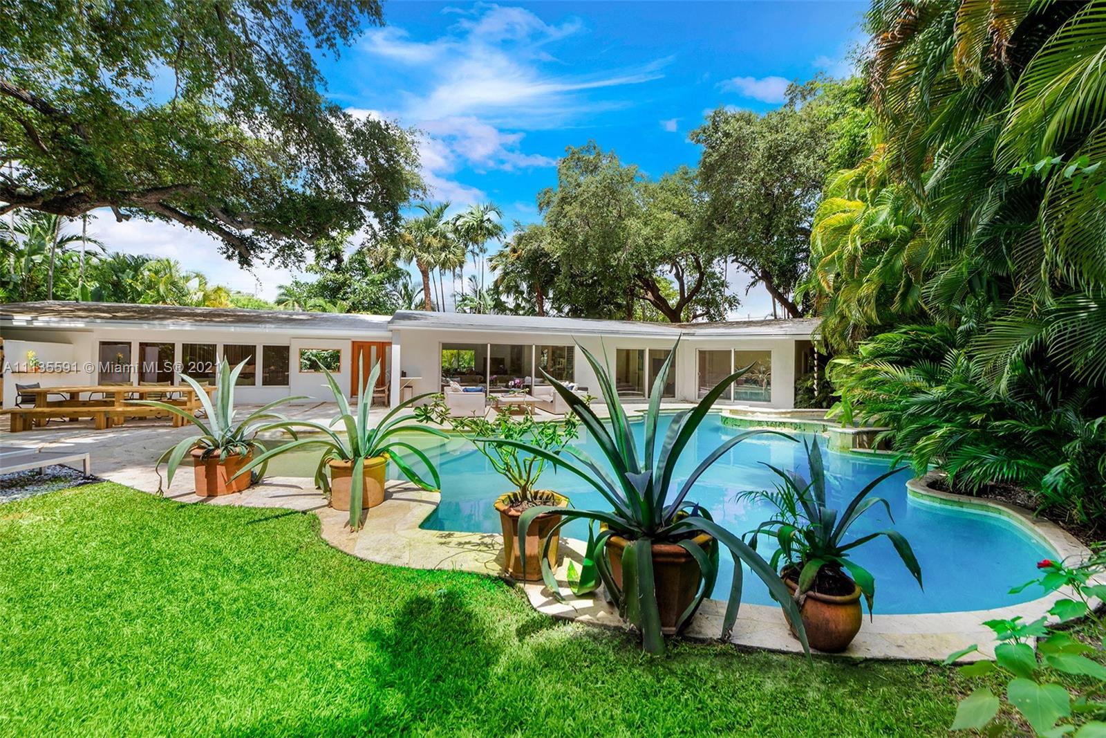 Furnished, Mid-Century home East of Biscayne in Miami Shores, tropical oasis under majestic oaks overlooking a heated free form walk-in pool with jacuzzi and water feature. This beautifully updated 4 bedroom, 3 bath, residence offers true indoor/outdoor living. The open floor plan features large rooms with floor to ceiling impact sliding doors throughout that exaggerate the lush greenery. Gourmet kitchen with quartz counter tops and Viking gas stove. Brand new master wing features walk-thru closet, custom dual sink vanity, oversized shower, and separate extra large soaking tub with a view of your private tropical oasis! Available 1/15/21, furnished only.