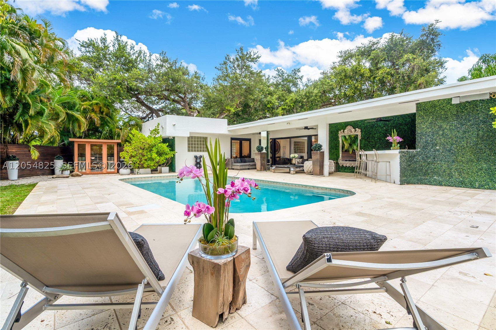 Tucked away on a quiet estate street in the highly desirable Skylake neighborhood, this exceptional 5-bedroom + den, 4.5-bath residence offers the perfect blend of luxury, comfort, and functionality. Situated on a spacious corner lot, the thoughtfully designed floor plan features two primary suites with renovated spa-inspired baths, plus generous guest accommodations. The kitchen has natural gas cooking, premium stainless-steel appliances, dual gas ranges, abundant storage with additional pantry, and a central island ideal for entertaining. A custom wet bar with Panda marble countertop, sink, and beverage cooler adds a sophisticated touch. Step outside to a resort-style retreat featuring a heated saltwater pool and infrared sauna. The outdoors has abundant greenery and nature all around offering total privacy with ample space for relaxing or entertaining. Additional highlights include porcelain flooring, a versatile den ideal for an office, gym, or media room, whole-house water filtration system, tankless gas water heaters, three zoned A/C systems, an outdoor climate-controlled storage, concrete block construction, and a location outside the flood zone. A three-way driveway provides easy access and ample parking for multiple vehicles. Conveniently located near top-rated schools, shopping, dining, and major highways. This property is within walking distance to several places of worship. Art, chandeliers and personal property are excluded from sale.