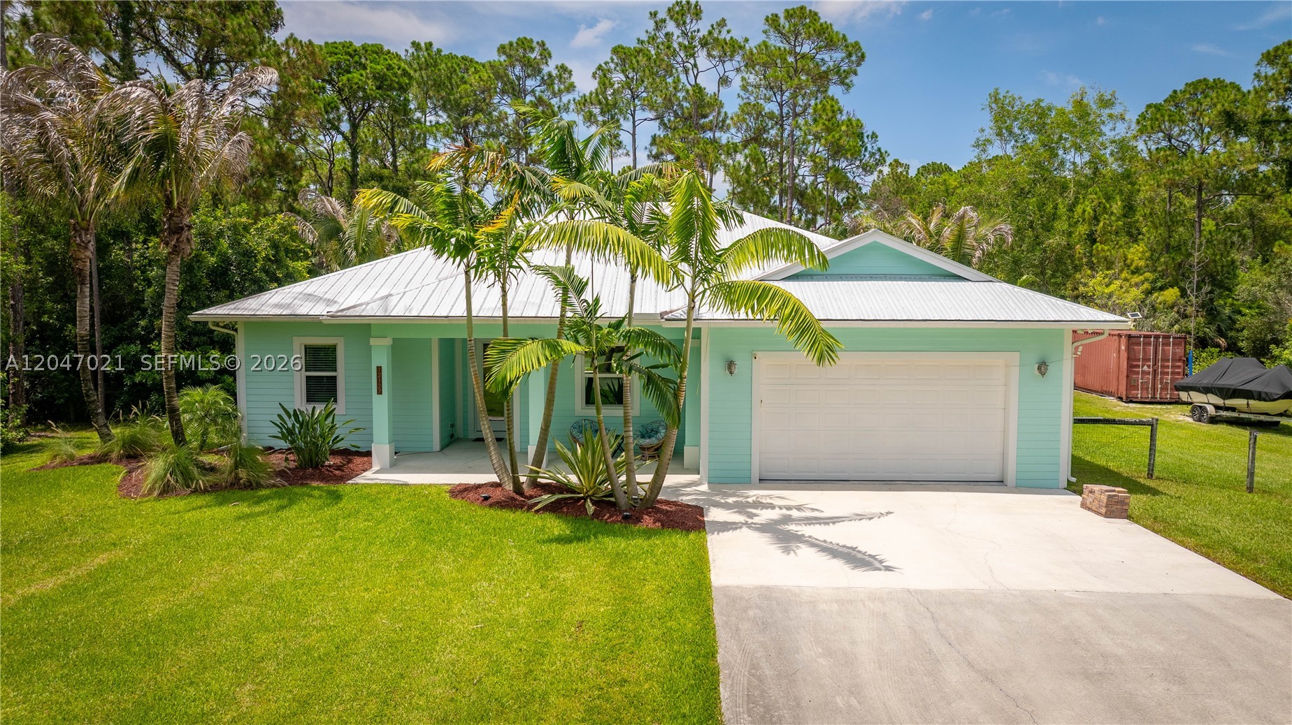 Welcome to your private retreat in the heart of Jupiter Farms! Built in 2018, this solid CBS home with a metal roof offers the perfect blend of comfort, quality and privacy on a beautifully maintained 1.25-acre fully sodded, irrigated lot. Lush tropical landscaping, swaying palms and a resort-style pool creates your own backyard oasis. Inside, you'll find plank tile throughout, a spacious great room with stunning coffered ceilings and wood inlay extending into the dining area and primary suite, impact windows, concrete siding, a separate laundry room, and a 2-car garage. The primary suite features dual vanities, a roll-in shower with a rainfall showerhead, a spa-like feel. Recent upgrades include a new well, a $10K+ water purification system, newer stainless steel appliances, fresh exterior paint, new fencing, a 50-amp RV hookup, generator connection with panel lockout, a second entrance with culvert and a 42-foot storage container. Conveniently located on a paved road in the desirable central area of Jupiter Farms, you're just minutes from major highways, shopping, dining, entertainment, golf and beautiful beaches. Move-in ready with room to relax, entertain and unwind. Enjoy the Jupiter Farms equestrian lifestyle with top-rated schools, welcoming neighbors and a high, dry lot. Bring your horses, chickens, RV, or other toys and enjoy the freedom of country living with city conveniences nearby. Furnishings are available for purchase separately. Call for a private showing.