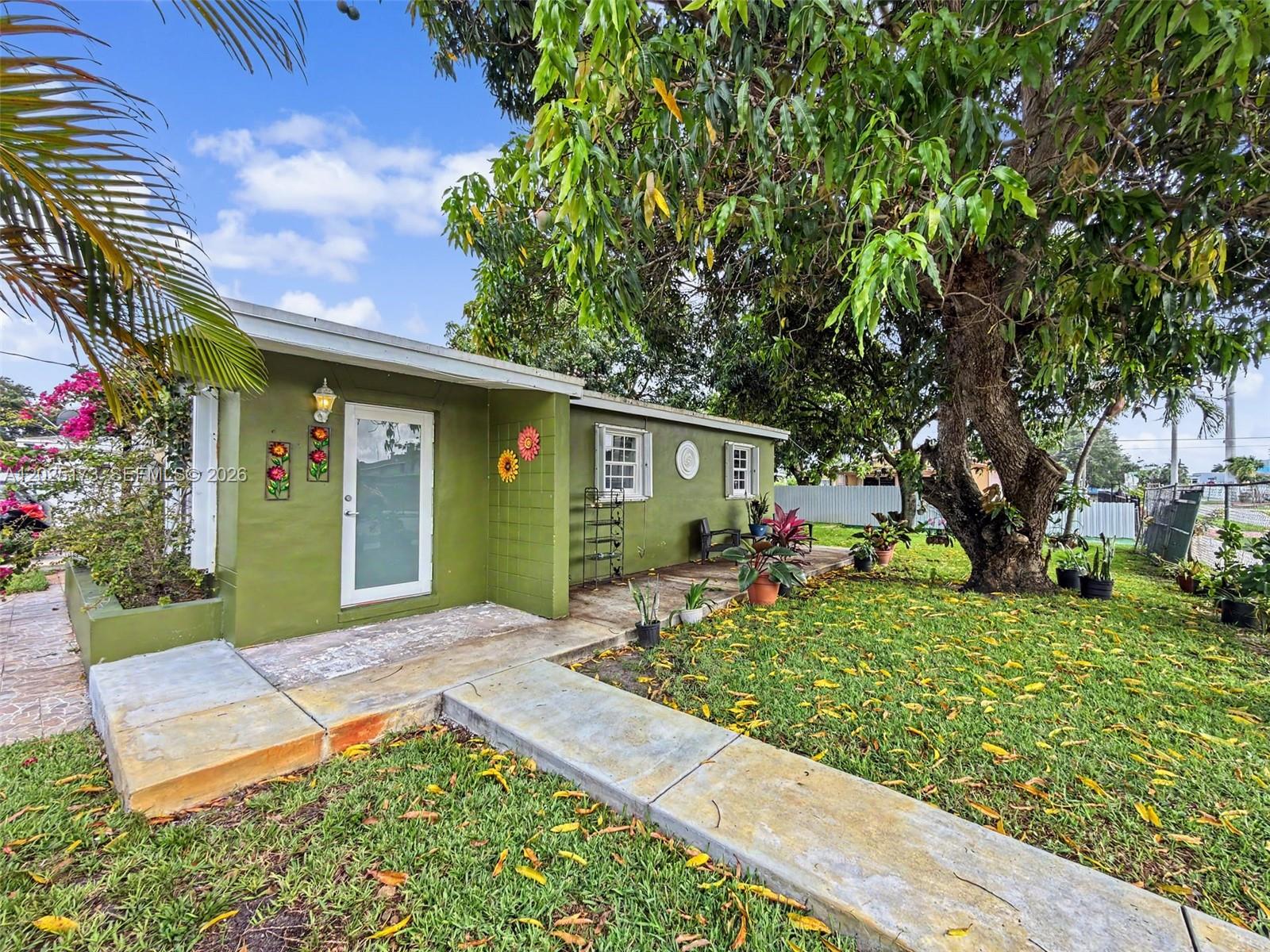 Discover this move-in ready 2-bedroom, 1-bath residence in the heart of Miami Gardens. Situated on a desirable corner lot, this charming home offers added privacy and curb appeal. Inside, you'll find brand-new flooring throughout, creating a fresh and modern feel. The bright and inviting layout flows seamlessly into a generous outdoor area, perfect for entertaining, relaxing, and enjoying South Florida living year-round. Surrounded by lush landscaping and mature mango trees that provide natural shade and a tropical atmosphere, this property offers a peaceful retreat with plenty of outdoor space to enjoy. Conveniently located near I-95, shopping, dining, and approximately 25 minutes from Sunny Isles Beach. Perfect for first-time buyers or a great investment opportunity.