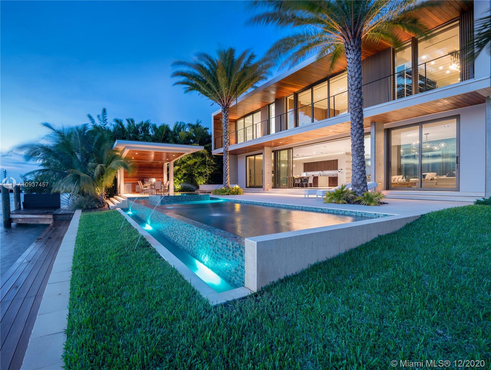 Experience luxury living in the finest bayfront mansion in exclusive Bay Harbor Islands where splendid sunsets over the wide bay & Indian Creek Island take center stage. Inside, oversized windows, exposed concrete, & warm tones of wood & marble decorate the bayfront living room with an open kitchen, formal dining with a chef’s kitchen concealed on the back, & large entry room - all surrounding a lush courtyard. Exceptional master suite with a marble bath, custom closet, & a private terrace takes the entire waterfront side. Luxe amenities including a sauna, infinity pool, spa, summer kitchen, dock, 2-car garage with a lift, staff, & an upper-floor family room will indulge the most discerning buyers. Created by the vision & dedication to perfection of Gamma Construction & CBDesign Team.