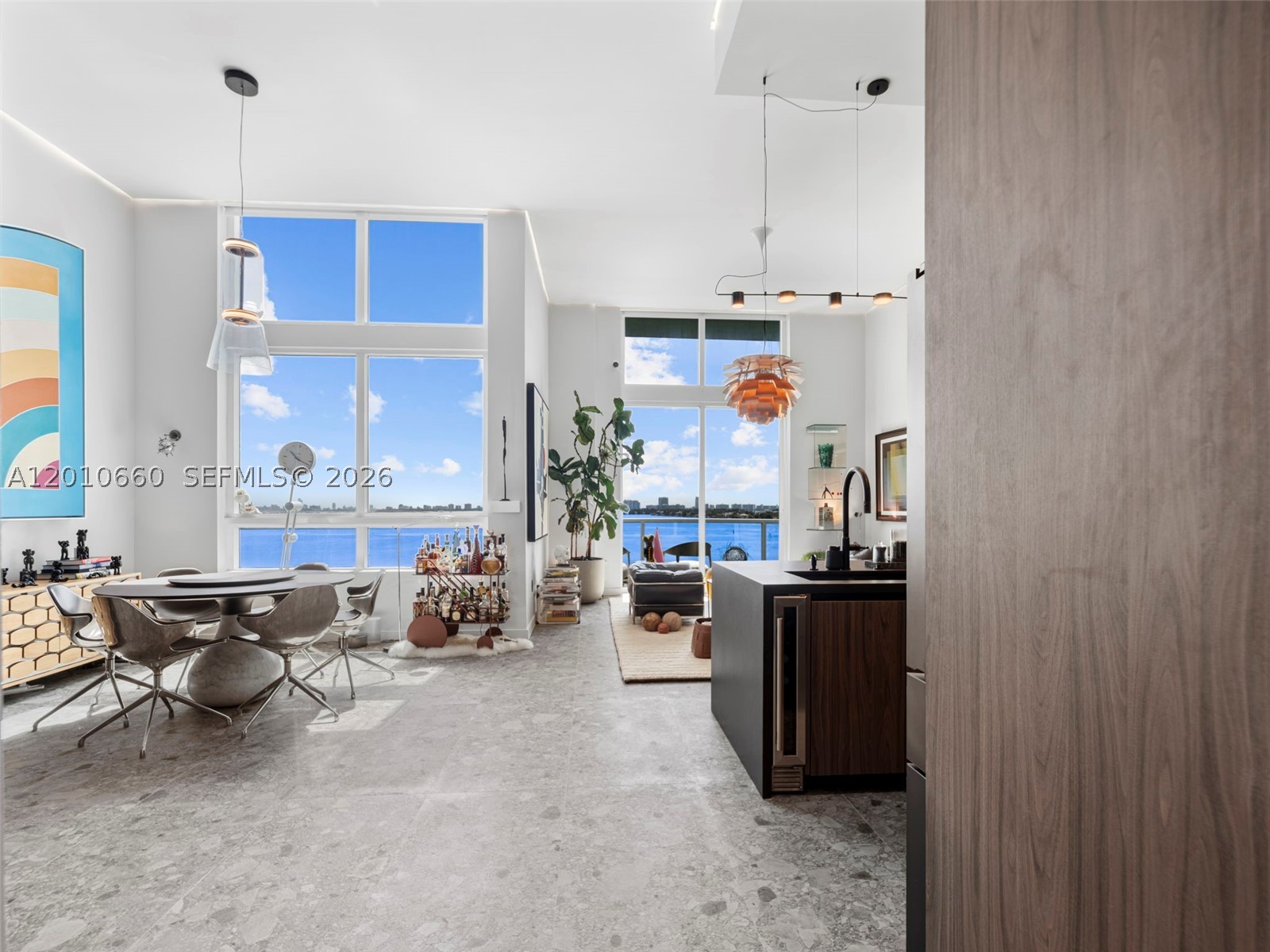 Experience elevated waterfront living in this fully renovated residence at Quantum on the Bay. Located on the 9th floor with sweeping views of Biscayne Bay and Margaret Pace Park. This exceptional 2-bed, 2-bath layout with 2 open terraces offers approx. 1,330 total square feet of refined interior and outdoor living. Defined by dramatic 14-foot ceilings and floor-to-ceiling glass, the home is filled with natural light, creating a seamless connection between the interior and bayfront beyond. The open-concept living and dining areas are anchored by a sleek designer kitchen featuring custom cabinetry, integrated appliances, and a striking island—perfect for everyday living and entertaining. The primary suite is a private retreat, complete with a custom walk-in closet and a spa-inspired bath finished in rich stone and contemporary fixtures. The secondary room is currently configured as a stylish den, offering flexibility to serve as a second bedroom, home office, or media lounge. Step outside to a private terrace overlooking the water and lush park below—an ideal setting for morning coffee or evening sunsets. Located directly across from Margaret Pace Park and moments from the Venetian Causeway, this residence offers effortless access to Miami Beach, Brickell, Wynwood, and the Design District. Residents of Quantum on the Bay enjoy resort-style amenities including two pools, a state-of-the-art fitness center, sauna, clubroom, and 24-hour concierge. Light fixtures and artwork are not included