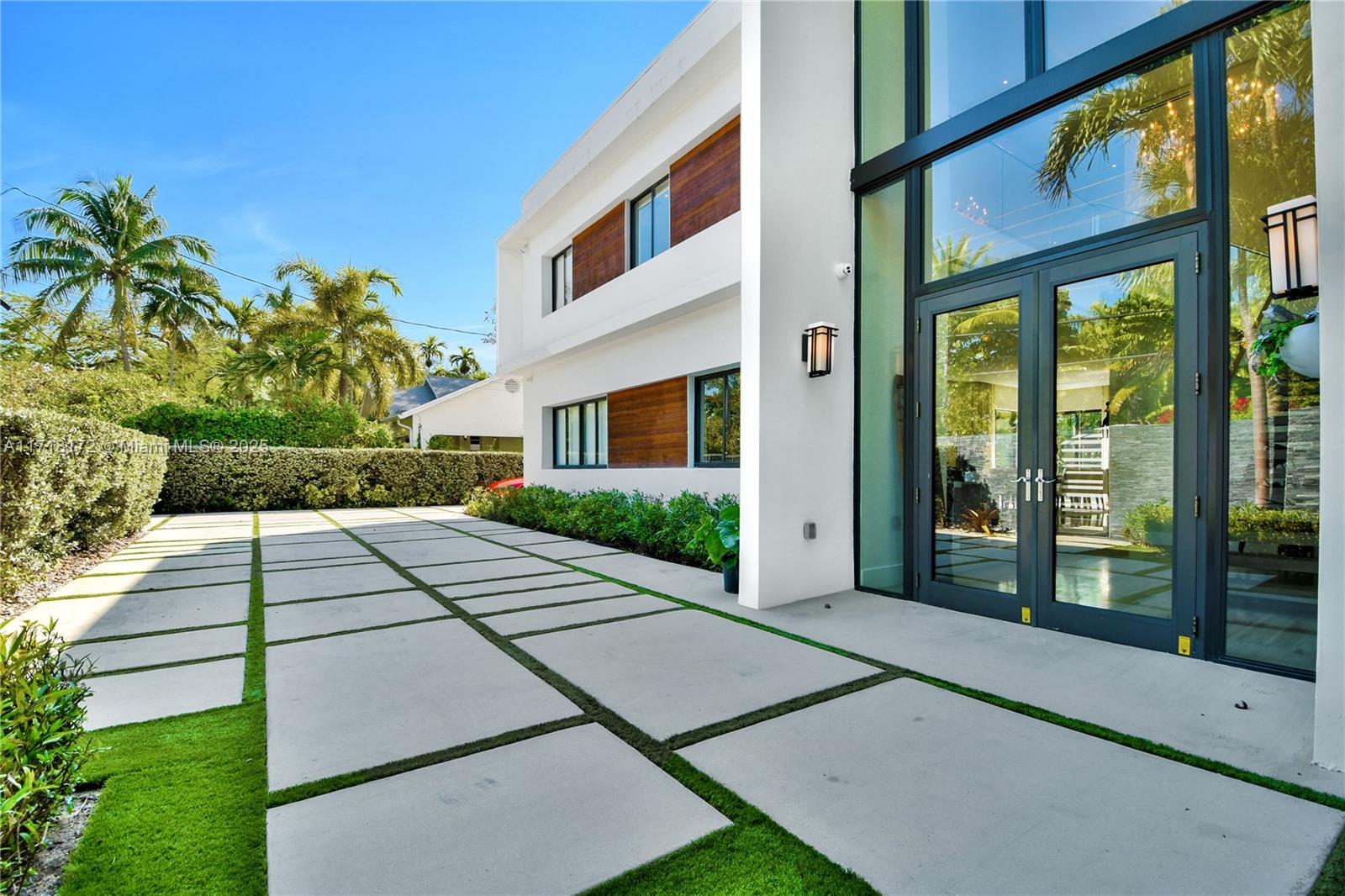 Excellence and sophistication define this custom-built modern masterpiece, designed with meticulous attention to detail and crafted with only the finest materials. From the moment you enter, the stunning floating staircase, set against a backdrop of soaring double-height ceilings, will take your breath away. Exquisite finishes include marble and real wood floors. Expansive high quality impact windows bathe the home in natural light, making every room feel bright and inviting. Whether you choose to leave the curtains open or enjoy the convenience of motorized blackouts, the atmosphere remains serene and refined. The chef’s kitchen, equipped with top-of-the-line Viking and Sub-Zero appliances, is a culinary enthusiast’s delight, and custom-built closets provide ample storage throughout.