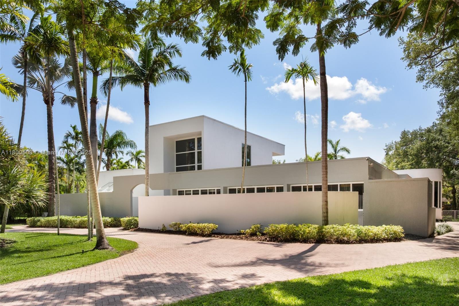 Step into refined luxury at this reimagined contemporary estate, nestled on a gated deep acre along one of North Pinecrest’s most prestigious streets. Fully renovated and filled with natural light, this home features soaring ceilings, marble floors, elegant formal living and dining rooms, and a gourmet natural stone kitchen with bar that opens to a spacious family room. Enjoy views of the beautifully landscaped grounds and oversized open pool. The split floor plan includes a separate upstairs loft with full bath, a lavish primary suite with spa-like bath, custom walk-in closets, and private office, plus three ensuite bedrooms in the children’s wing and a maid/guest suite. An expansive covered patio and a gated entry complete this entertainer’s dream.