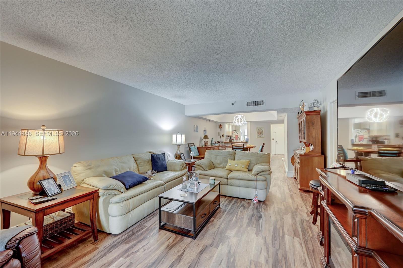 Recently painted with new vinyl plank flooring and new chandelier. Has accordion shutters, garbage disposal and updated bathrooms. 1 assigned covered parking spot and Guest parking. Enjoy the community pool. Washer and dryer in unit.