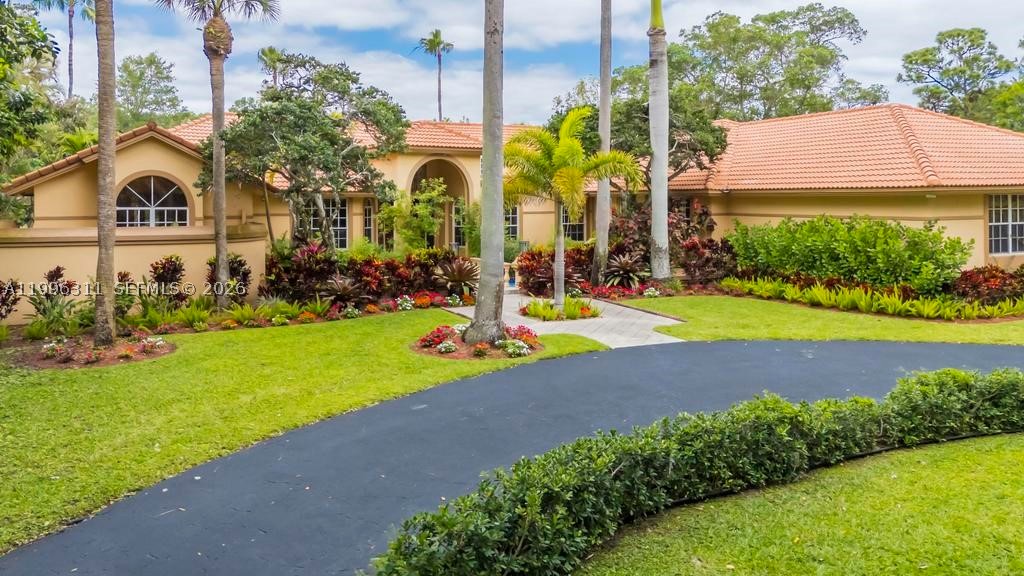 Experience luxury lakefront living in this extraordinary custom estate located within one of Coral Springs’ most exclusive gated communities. Situated on over an acre with breathtaking water views, this one-story residence offers over 5,200 SF of living space with 6 bedrooms and 5.5 bathrooms. A dramatic entrance featuring a stunning water feature and bridge-style walkway leads into expansive living spaces filled with natural light, marble flooring throughout the main areas, and rich Brazilian cherry wood floors in the bedrooms. Designed for both elegant entertaining and comfortable everyday living, the home features spacious formal and casual living areas, a grand dining room, and an updated kitchen with custom wood cabinetry, granite countertops, and stainless steel appliances. The expansive primary suite offers a private retreat, while the additional bedrooms are thoughtfully tucked away on the opposite side of the home, creating exceptional privacy and functionality. Oversized windows showcase serene lake views throughout, while the resort-style outdoor space features an expansive covered patio, lakefront pool, and endless room to relax and entertain in complete privacy. A rare opportunity to own a true custom estate that combines timeless architecture, exceptional space, and an unmatched setting in South Florida.