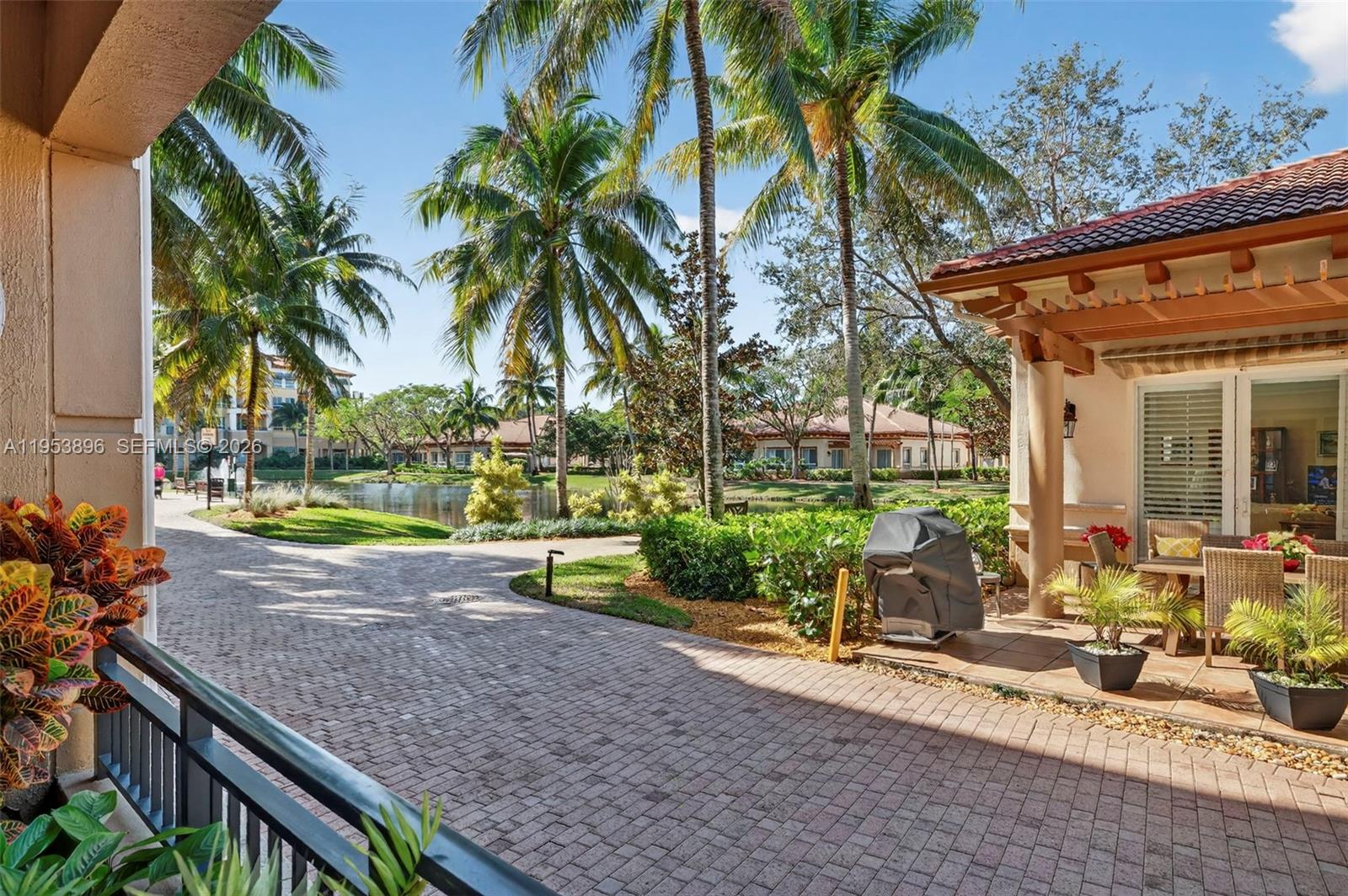 Welcome to this coveted first-floor corner residence in the highly sought-after, guard-gated 55+ community of Palms at Weston – Island House. This spacious 2-bedroom, 2.5-bath condo offers serene lake views and the rare convenience of its own private balcony gate with direct access to the pavered walking paths & resort-style amenities. Kitchen features wood cabinetry, new marble countertops & backsplash, new stainless-steel appliances, and a spacious eat-in area. Open layout showcases crown molding, recessed lighting, fresh paint, and neutral tile flooring throughout the main living areas, with new laminate flooring in both bedrooms. Impact glass windows and doors. The primary suite includes a walk-in closet w/ built-ins, double vanity, separate shower, and a relaxing jacuzzi tub. Additional highlights include a newer washer/dryer, water heater & A/C replaced in 2019. Enjoy luxury amenities including a resort-style pool and 2 spas, fitness center w/ sauna & steam room, clubhouse, library, beauty salon, on-site restaurant, concierge services, card room, complimentary valet and on-site health care agency. Maintenance fees include internet/cable, water, trash, and a $180 quarterly restaurant credit. An exceptional opportunity to enjoy comfort, convenience, and an active lifestyle in one of Weston’s premier communities. Fantastic location - close proximity to Cleveland Clinic, major highways, Publix & many restaurants.