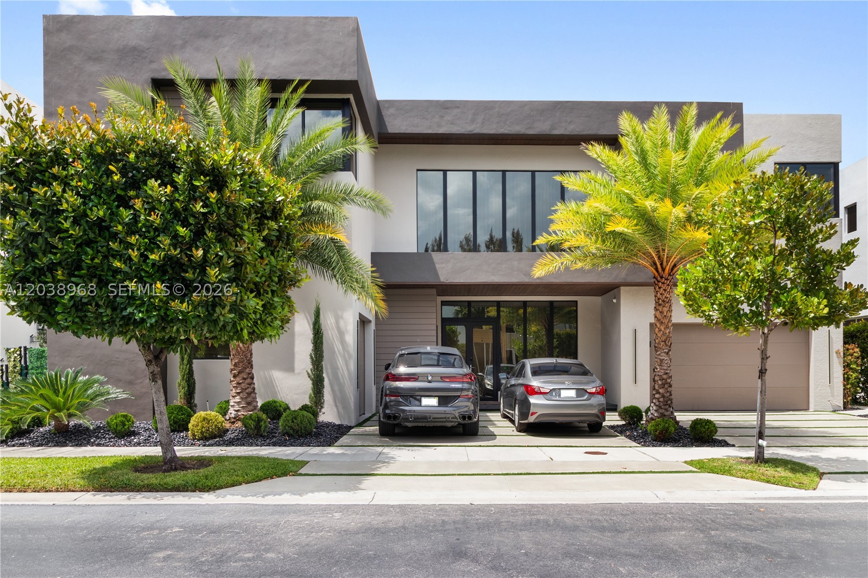 Rare opportunity in Modern Doral 75! Magnificent lakefront estate featuring extensive brand-new upgrades. Enjoy a newly built infinity pool overlooking the water, a fully remodeled modern chef's kitchen, a redesigned garage, and a striking new exterior facade. This 5BR/6BA contemporary home shines with double-height ceilings, premium smart-home technology, custom Italian finishes, and an open layout tailored for entertaining. Located in a secure gated community just minutes from premier golf, dining, and shopping. Turnkey luxury at its finest!