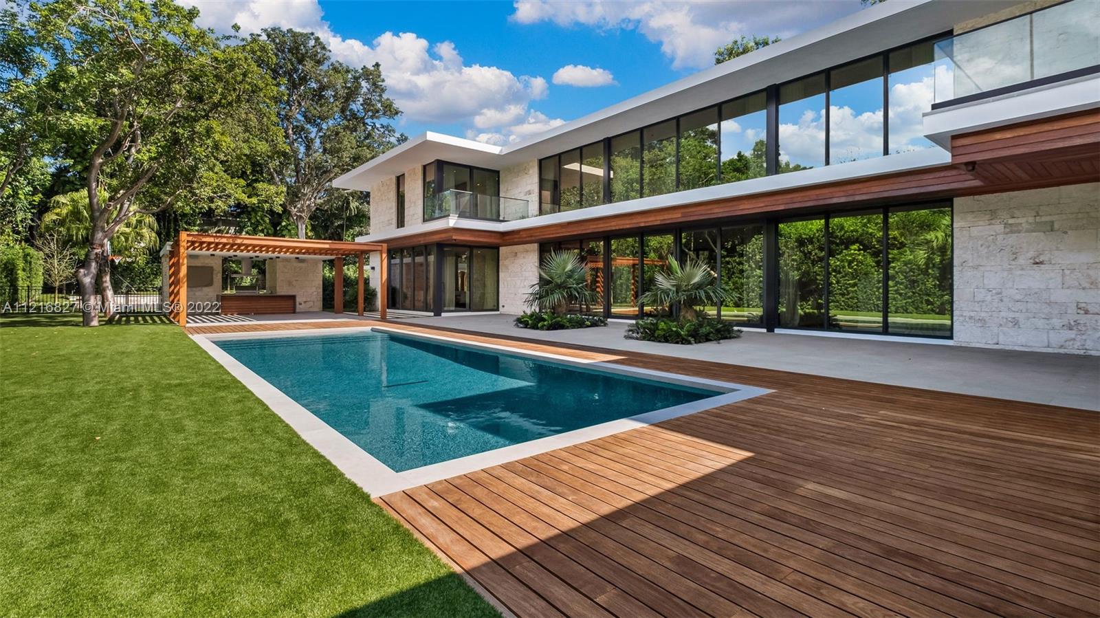Stunning mid-century modern estate nestled inside the sought-after guard gated community of Hammock Lakes. Custom built by Mocca Construction and designed by architect Max Strang; known for unifying functional interior spaces with outdoor landscapes. 9,254 total square feet including 7bedrooms, 6 baths, 2 half baths, as well as abundant tropical landscaping. Pristine attention to detail using only the finest materials with minimalistic vibe.