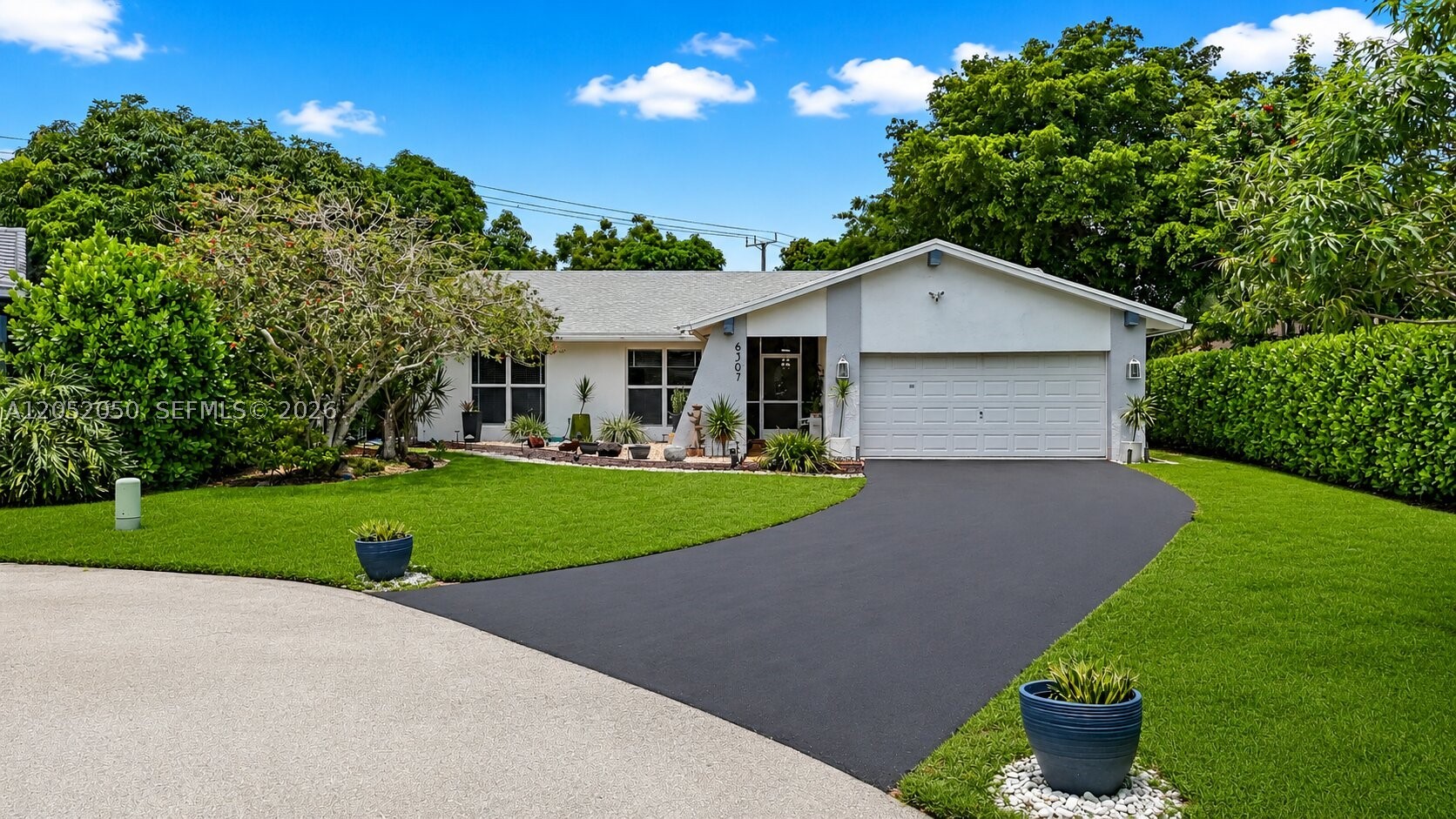 Welcome to The Woodlands, one of Tamarac's most established communities. Tucked at the end of a quiet cul de sac, this fully renovated 3 bedroom, 2 bathroom home with 2 car garage offers over 2,100 sq ft of living space plus an oversized enclosed patio and family room, easily converted to a 4th bedroom, office, or media room. The big ticket items are already done: Roof 2021, water heater 2021, AC 2018, and impact windows throughout. Inside you'll find wood flooring, an updated kitchen with newer appliances, and a bright, comfortable layout made for everyday living. Out back is where this home really shines. A newly built outdoor kitchen with gas and electric hookups anchors the screened patio, and the huge backyard is dotted with mature fruit trees. The extra long driveway comfortably fits up to six cars. All of this just a short stroll from the community pool, clubhouse, and golf course, with a very low HOA. Move in ready. Homes like this in The Woodlands don't come around often. Schedule your private showing today.