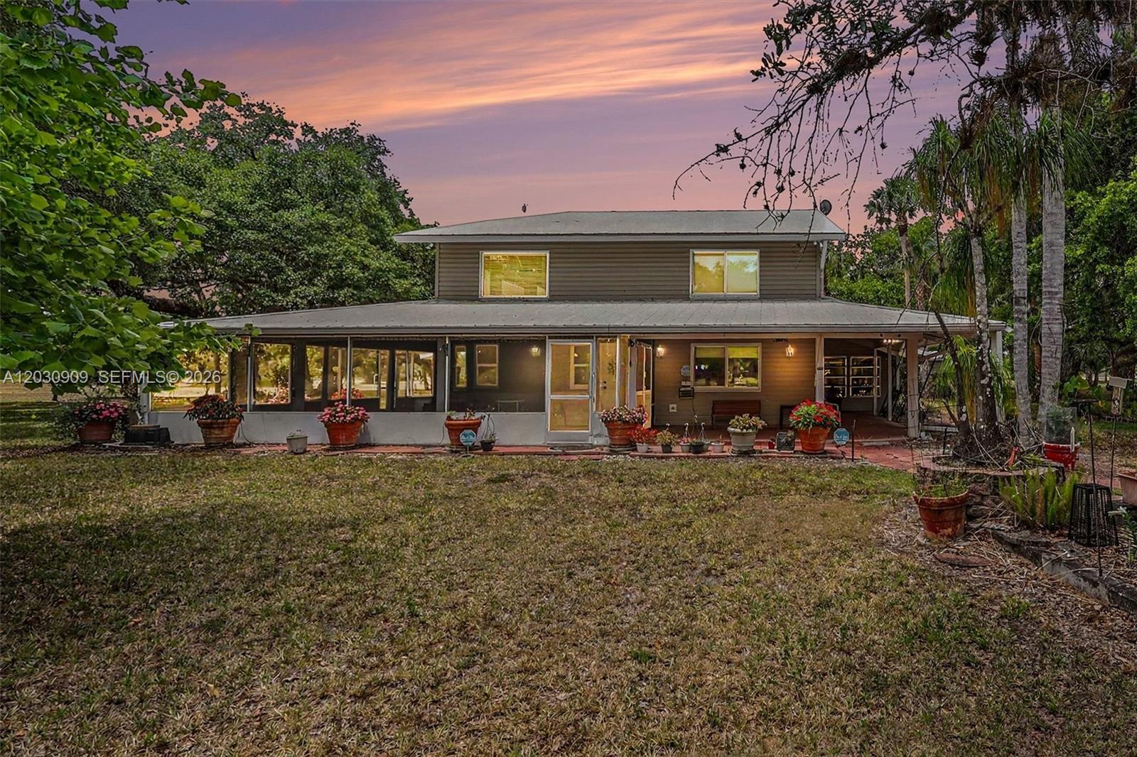 Welcome to one of the most beautiful homesites in Port LaBelle Ranchettes—a breathtaking 11.21± acre estate comprised of two Port LaBelle Ranchettes parcels, set in a magnificent park-like landscape of towering oak trees that showcase the natural beauty LaBelle is famous for. This rare property offers privacy, space, and exceptional improvements in one of the area's most desirable acreage communities. The centerpiece is a beautifully designed 4,500± square foot custom residence featuring 3 bedrooms, 2 full baths, and 1 half bath, constructed with 2x6 framing, vinyl siding, and topped with a durable Galvalume metal roof. Inside, the home is warm, inviting, and architecturally impressive. The dramatic two-story great room boasts a soaring cathédral ceiling, stunning upper-level picture windows with decorative fanlights, and a striking stone fireplace that anchors the living space. Multiple sliding glass doors open to Florida room areas, while a charming bay window reading/TV nook creates a cozy place to relax and enjoy the views. Designed for Florida living, the home is surrounded by generous outdoor living spaces, including open tiled porches wrapping nearly half the home, a screened porch, and a spacious Florida room that extends along two sides of the residence, blending indoor comfort with outdoor beauty.