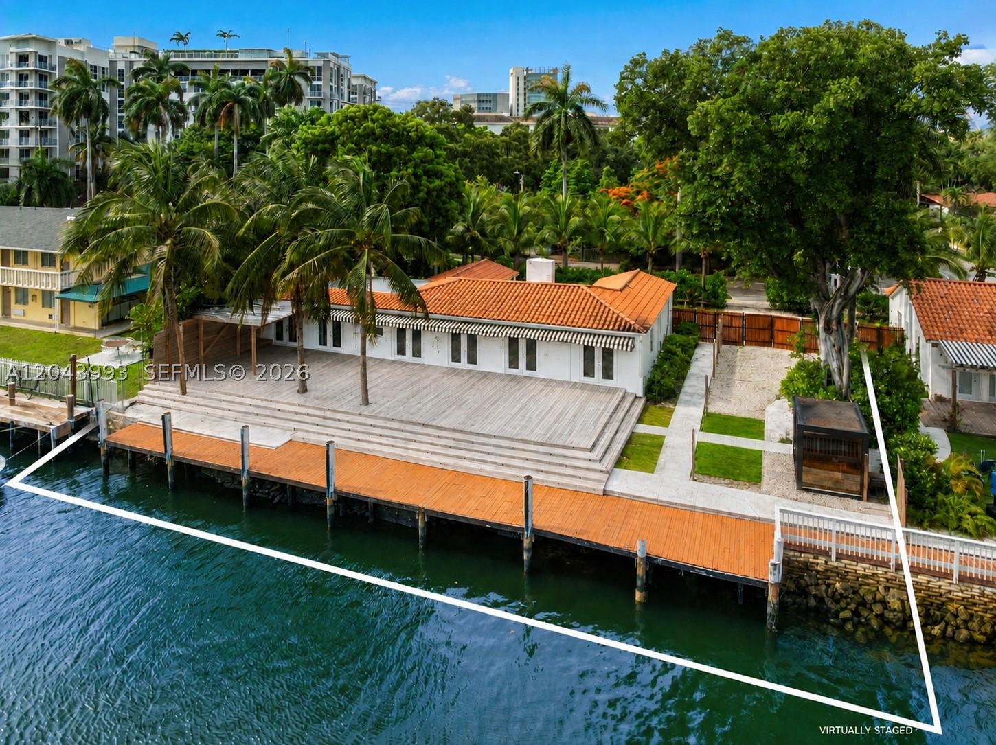 A rare riverfront offering in historic Spring Garden, one of Miami’s most charming and centrally located neighborhoods. Set on a deep 13,915 SF lot with 98 feet of Miami River frontage, this renovated 4BD/3BA residence pairs warm architectural character with a true boater’s lifestyle. Interiors span 2,195 SF and feature soaring wood-beam ceilings, stone flooring, generous living and dining areas, and a center-island kitchen opening through French doors to an expansive waterfront deck. Outside, a large private dock creates an exceptional setting for boating, entertaining, and enjoying the energy and movement of the Miami River. Sited in a tranquil, canopied neighborhood known for its broad streets, large lots, mature shade trees, and two parks, the home offers a rare blend of historic character, waterfront living, and immediate proximity to Downtown, Brickell, Wynwood, Miami Beach, the Health District, and Miami International Airport.