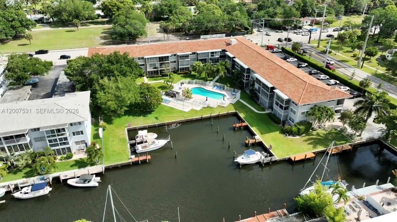 Enjoy looking out from your screened-in porch—Florida waterfront living. 2 BD | 2 BTH residence in a gated community offering beautiful garden views and open sightlines to the pool. This well-positioned unit features a bright, airy layout with seamless living spaces filled with natural light. Start your mornings fishing just steps away, then unwind or entertain at the heated pool with friends. Ideally located just minutes from Las Olas Blvd, premier Las Olas shopping and dining, Fort Lauderdale Beach, downtown Fort Lauderdale, major highways, and Fort Lauderdale International Airport. Walk to local restaurants and bars. No special assessments and no age restrictions. Well-maintained community with pool and BBQ area; pets allowed. Suitable for seasonal or year-round living. No rentals permitted. Rare opportunity to own side-by-side units—this is neighboring Unit 108, also available for purchase.