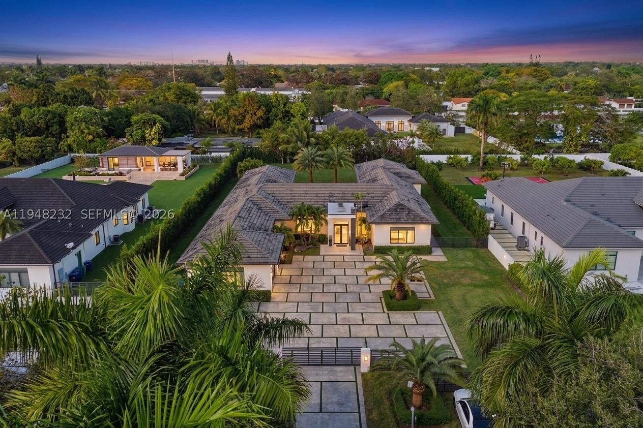 Elegant, expansive, and perfectly positioned in a peaceful neighborhood, this stunning newer-construction luxury estate offers 6 bedrooms, 7 bathrooms, and 5,850 sq. of refined single-story living. Designed with an open-concept layout, the home features soaring ceilings, exquisite chandeliers, and sophisticated architectural details that create a bright, welcoming atmosphere throughout. The thoughtfully planned split layout enhances privacy, while the primary suite serves as a true retreat with a spacious walk-in closet and spa-inspired bathroom. Ideal for entertaining, the designer kitchen and elegant living spaces are complemented by a custom wine display and seamless indoor-outdoor flow. The resort-style backyard includes a heated pool, outdoor BBQ area, and ample space to add a guest house, private gym, or pickleball court. Built for both luxury and resilience, the property offers spray-foam roof insulation, a full-house gas generator, storm drainage surrounding the home, Sonos sound system, evenly distributed Wi-Fi, and security cameras. Additional highlights include a massive driveway, lush tropical landscaping with coconut, guava, and ciruela trees, abundant natural light, and no HOA. Conveniently located near top-rated schools, dining, and major conveniences, this exceptional residence delivers privacy, sophistication, and endless possibilities in a highly sought-after neighborhood.