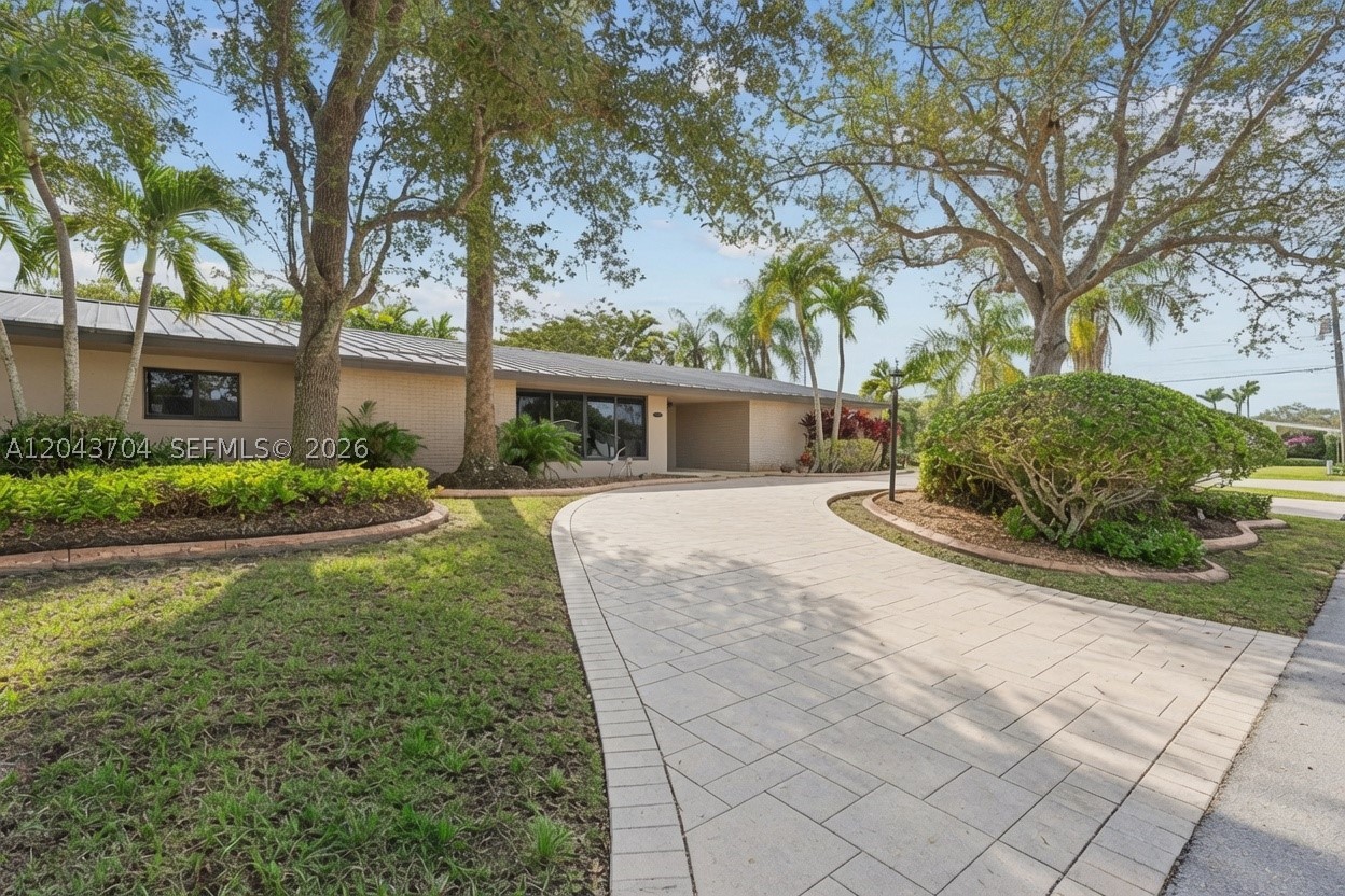 Set along historic Old Cutler Road in sought-after Tanglewood Estates, this beautifully updated residence sits on a lush 0.35-acre corner lot framed by mature landscaping for exceptional privacy. The bright, open floor plan offers 4 bedrooms and 3 bathrooms, including two private suites, creating a flexible layout for everyday living and guests. The spacious kitchen is appointed with custom wood cabinetry, granite countertops, and stainless steel appliances, while travertine and wood-look porcelain tile flooring flow throughout the home. Expansive impact glass doors open to a private backyard retreat featuring an oversized pool, covered patio, and beautifully landscaped grounds designed for year-round outdoor living. Recent upgrades include impact windows and doors and a durable metal roof. Moments from Pinecrest, schools, parks, and neighborhood amenities.