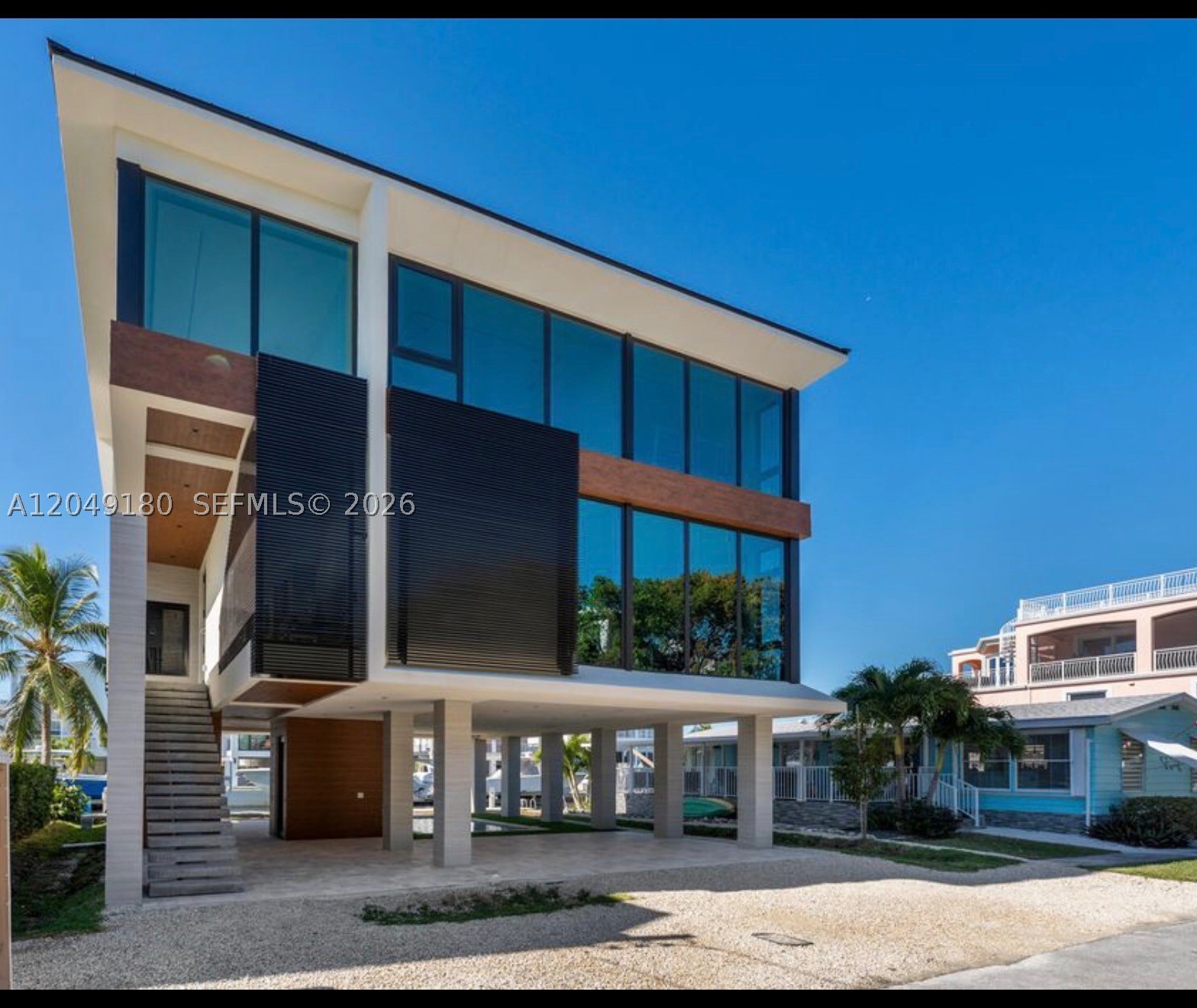 Experience the ultimate in modern waterfront luxury with this brand-new concrete masterpiece, thoughtfully designed for both elegance and durability. Boasting 4 bedrooms and 4 bathrooms, this stunning residence offers breathtaking ocean views, a protected canal location, 55 feet of dockage, and 15,000 lb boat lift for effortless boating access. Built to the highest standards with a concrete roof, impact-resistant windows and doors, and an elevator servicing all levels, this exceptional home blends sophisticated design with everyday convenience. The show- topping custom Italian kitchen is beautifully appointed with premium Miele appliances, sleek cabinetry, and designer finishes, creating the perfect space for entertaining. Step outside to your private backyard oasis featuring a sparkling saltwater pool with premium equipment, ideal for relaxing after a day on the water. Additional luxury features include whole-home surround sound, a security camera system, and high-end finishes throughout. Located in an exclusive private community with a clubhouse for special events, this property combines luxury, security, and the Florida Keys waterfront style.