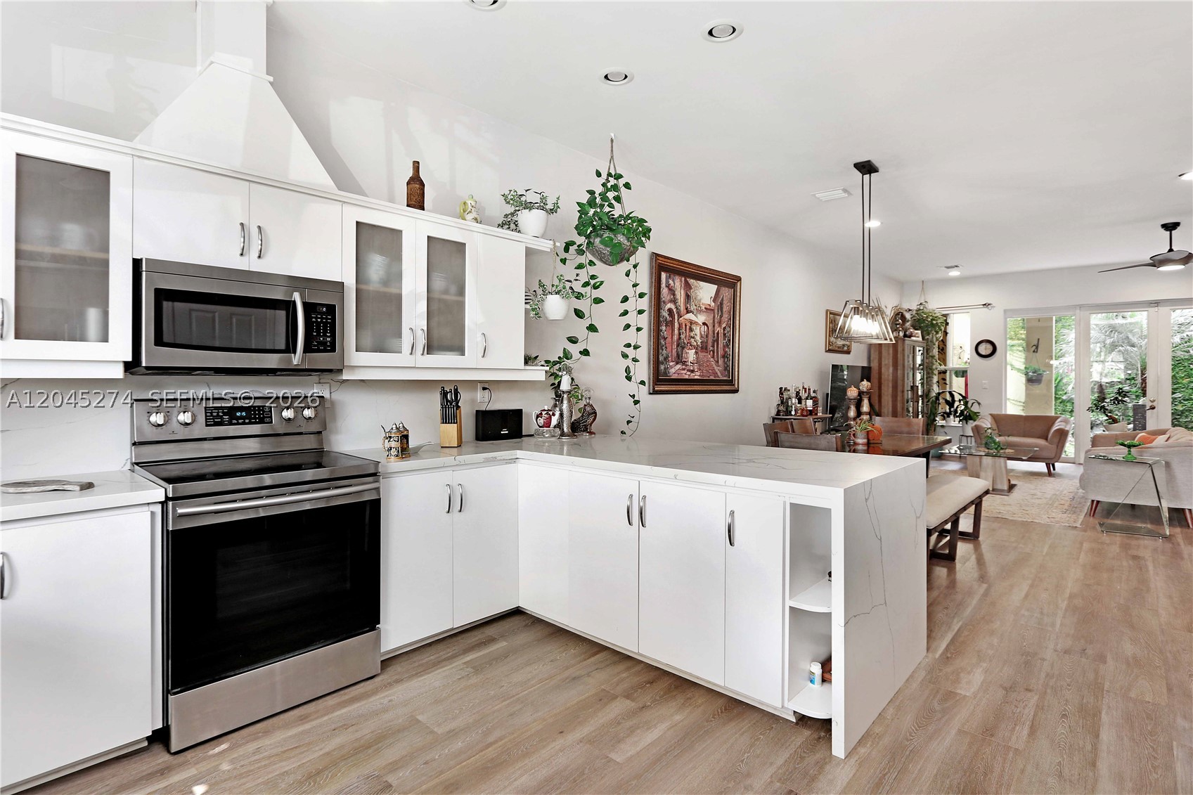 Rare opportunity in the heart of East Hollywood! This inviting 3 bedroom, 2.5 bath townhome offers the perfect blend of space and comfort, complete with a 2 car garage and a private rooftop terrace where you can unwind and take in the city views. The open living area features volume ceilings, crown molding, and warm wood flooring that flows throughout, creating a welcoming atmosphere from the moment you walk in. Enjoy a formal dining space for gatherings and a bright kitchen with stainless steel appliances, granite countertops, white cabinetry, pantry storage, and a convenient sit-down bar for casual meals. All bedrooms are tucked away upstairs for added privacy, including a spacious primary suite with its own balcony and a relaxing bath with separate shower and jacuzzi tub. A cozy sitting area at the top of the staircase and additional storage under the stairs add to the thoughtful layout. With a fenced front yard, a private rear courtyard, and only six townhomes in the community, this home offers both charm and privacy. Ideally located just minutes from the famous Hollywood Broadwalk, beautiful beaches, Downtown Hollywood, shopping, and dining — this is South Florida living at its best.