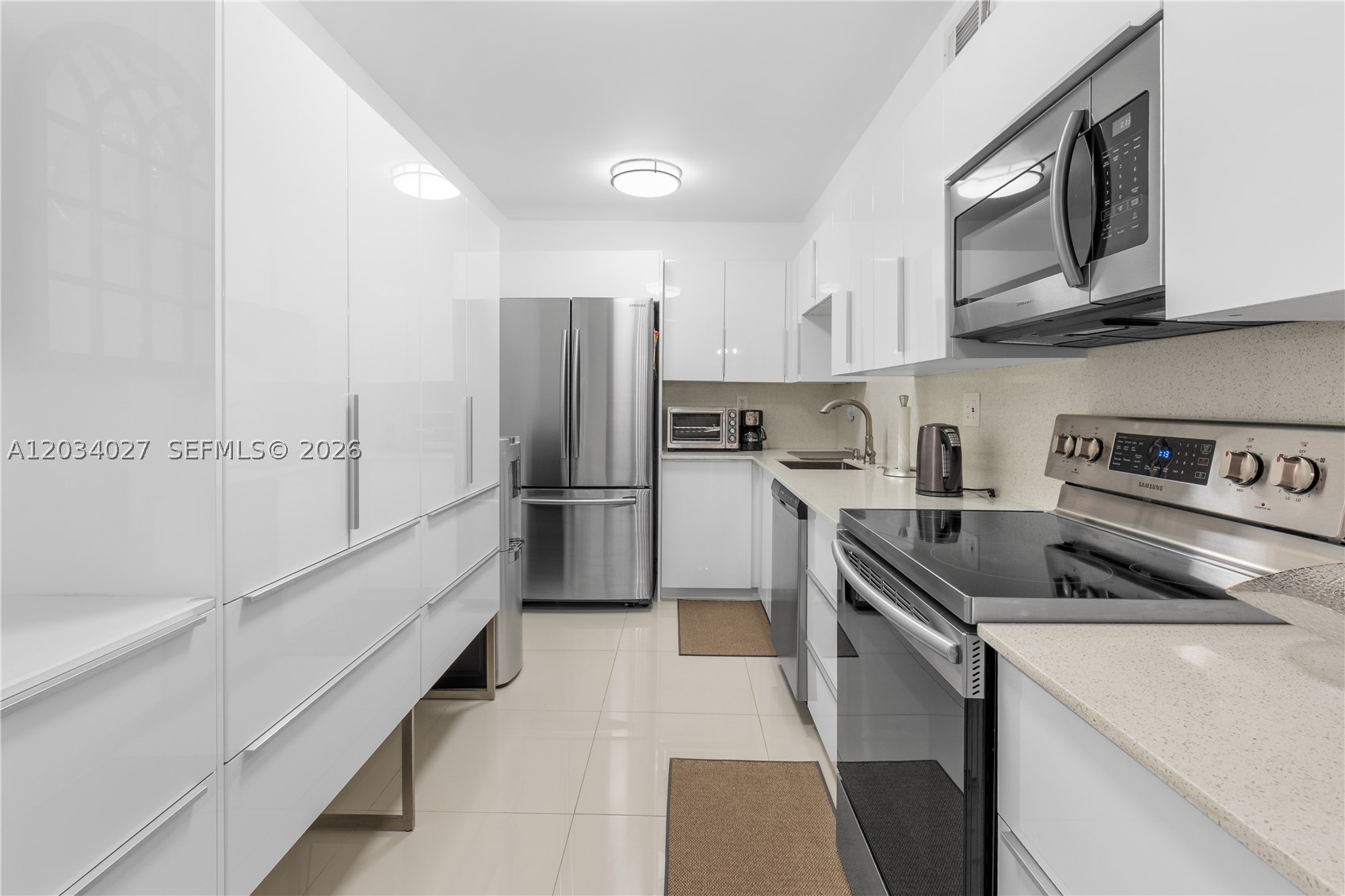 Renovated kitchen and bathrooms offer contemporary finishes, glass-enclosed showers, and updated fixtures throughout. Both bedrooms are generously sized, providing comfort and privacy ideal for families, guests, or a home oftice setup. Brand new AC and hurricane impact windows. All assessments have been paid off. Enjoy a well-maintained building with security, a sparkling pool, fitness center, and beach access just across the street.