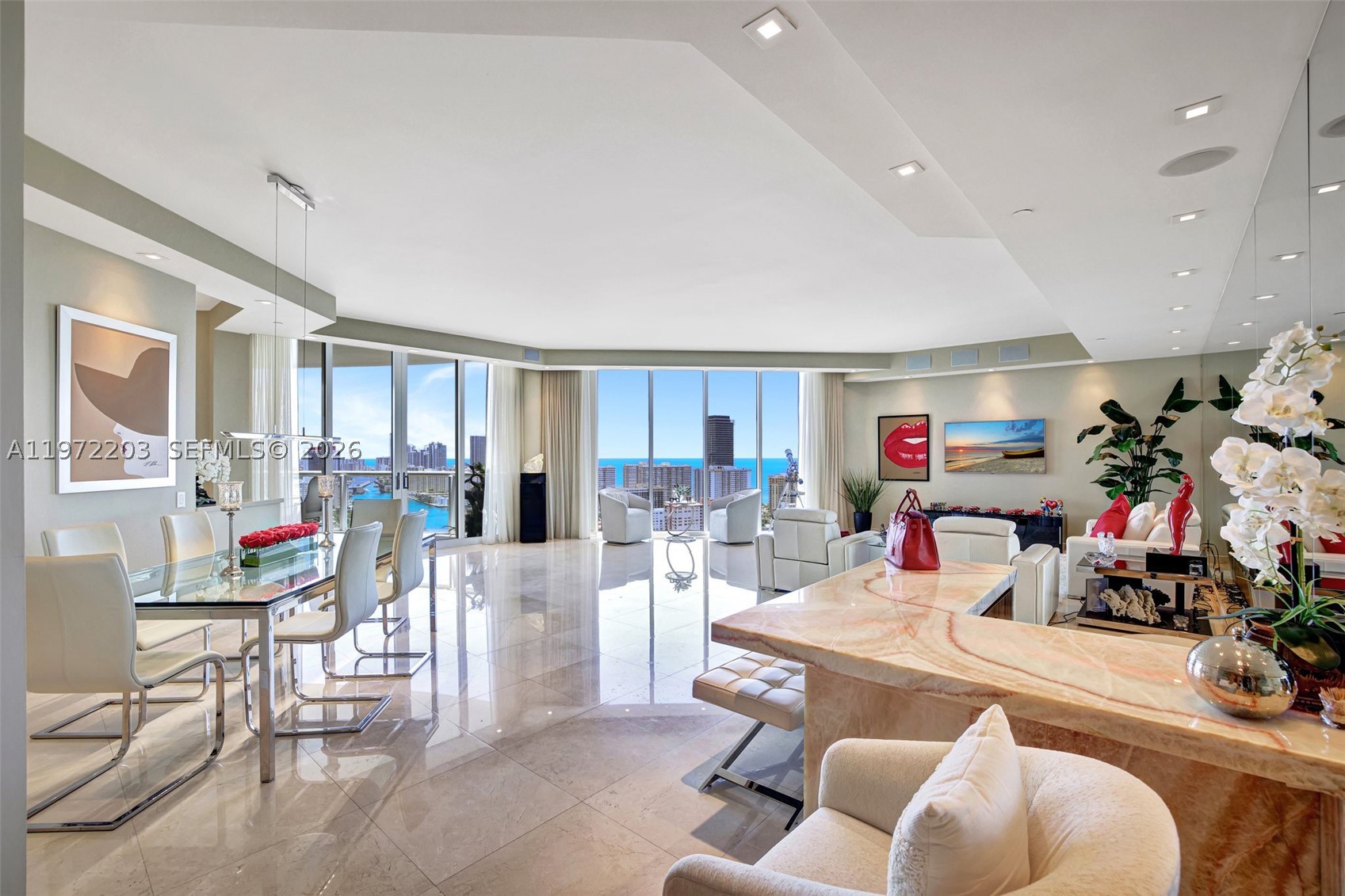 Wow! Welcome To The Epitome Of Luxury In This Extraordinary Penthouse In Atlantic One At The Point. This stunning 3 bedroom, 3.5 bathroom palace in the sky boasts roughly 3,173 square feet of living space. Enter from private elevator and be greeted by high ceilings into a stunning space illuminated by natural light. Enjoy panoramic views of the ocean, Intracoastal, and city skylines from two large terraces. This Penthouse has been renovated to include the finest finishes, including all impact glass windows, electric shades, LED lighting, marble floors, color changing light up Onyx bar, Italian glass doors, and a state-of-the-art redone kitchen with Subzero, Wine Cooler, etc. The primary suite is spacious and features a redone bathroom.
This property is perfect for those seeking a luxurious lifestyle in a prime location. Enjoy the resort lifestyle that only The Point can offer. The community features a renovated 25,000 square foot resident's club, juice bar, gym, spa, four tennis courts, three pools, BBQ area, kids' playground, and more. Seller Financing Available!
