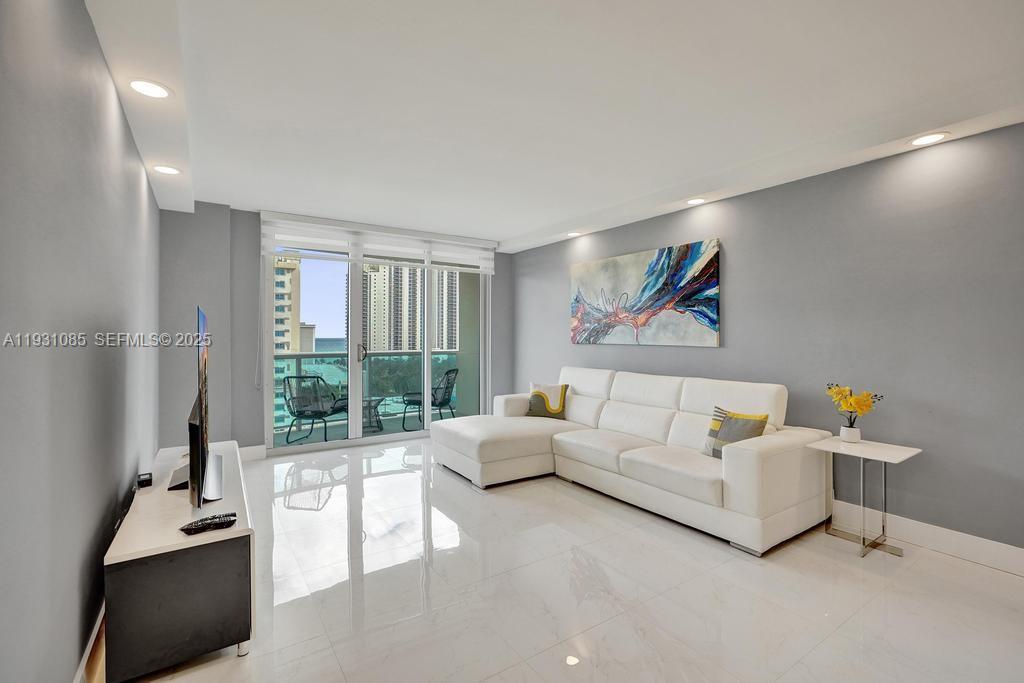 Fully remodeled, bright, modern, and spacious residence offering breathtaking ocean, intracoastal, and open city views. This beautifully updated apartment features a generous open-concept living and dining area with glossy white tile floors, recessed lighting, and floor-to-ceiling sliding glass doors that flood the space with natural light and create a seamless indoor-outdoor feel. The renovated kitchen showcases sleek white cabinetry, quartz countertops, stainless steel appliances, and a functional island that opens directly to the main living area—ideal for both everyday living and entertaining. The home offers exceptional storage, including large walk-in closets and a rare dedicated closet room. The spacious balcony, accessible from the living area, provides open views and ample room for comfortable outdoor seating. The unit feels light, airy, and well-proportioned, with clean, modern finishes throughout. Additional features include A/C (2020), hurricane-impact windows and balcony doors installed approximately 10 years ago, and completion of the building’s 40-year recertification. One covered parking space is included. Rentals are allowed up to two times per year. Enjoy a full-service, oceanfront lifestyle with amenities that include a pool, fitness center, 24-hour security, and direct beach access. Ideally located within walking distance to the ocean, shopping, dining, and parks, and situated near A-rated schools.